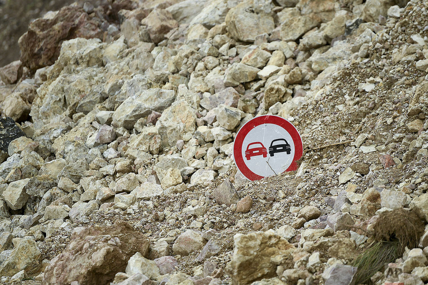  A traffic sign pokes out from the debris of a landslide triggered by a 7.2 magnitude earthquake, alongside a road in Rampe, Haiti, Aug. 18, 2021. (AP Photo/Matias Delacroix) 