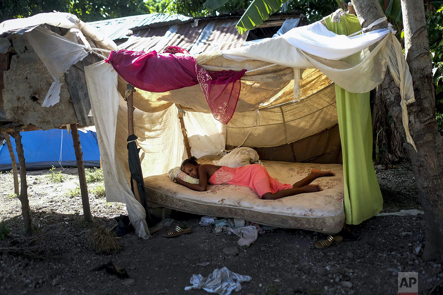  A youth sleeps outside her home in Saint-Louis-du-Sud, Haiti, Aug. 16, 2021, two days after a 7.2-magnitude earthquake struck. (AP Photo/Matias Delacroix) 