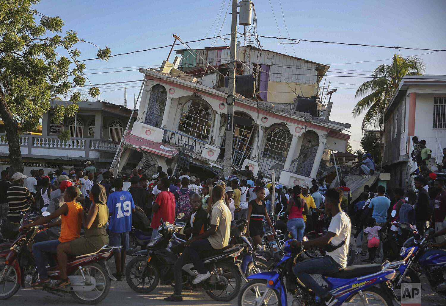  Residents gather outside the Petit Pas Hotel, destroyed by a 7.2 earthquake, in Les Cayes, Haiti, Aug. 14, 2021. (AP Photo/Joseph Odelyn, File) 