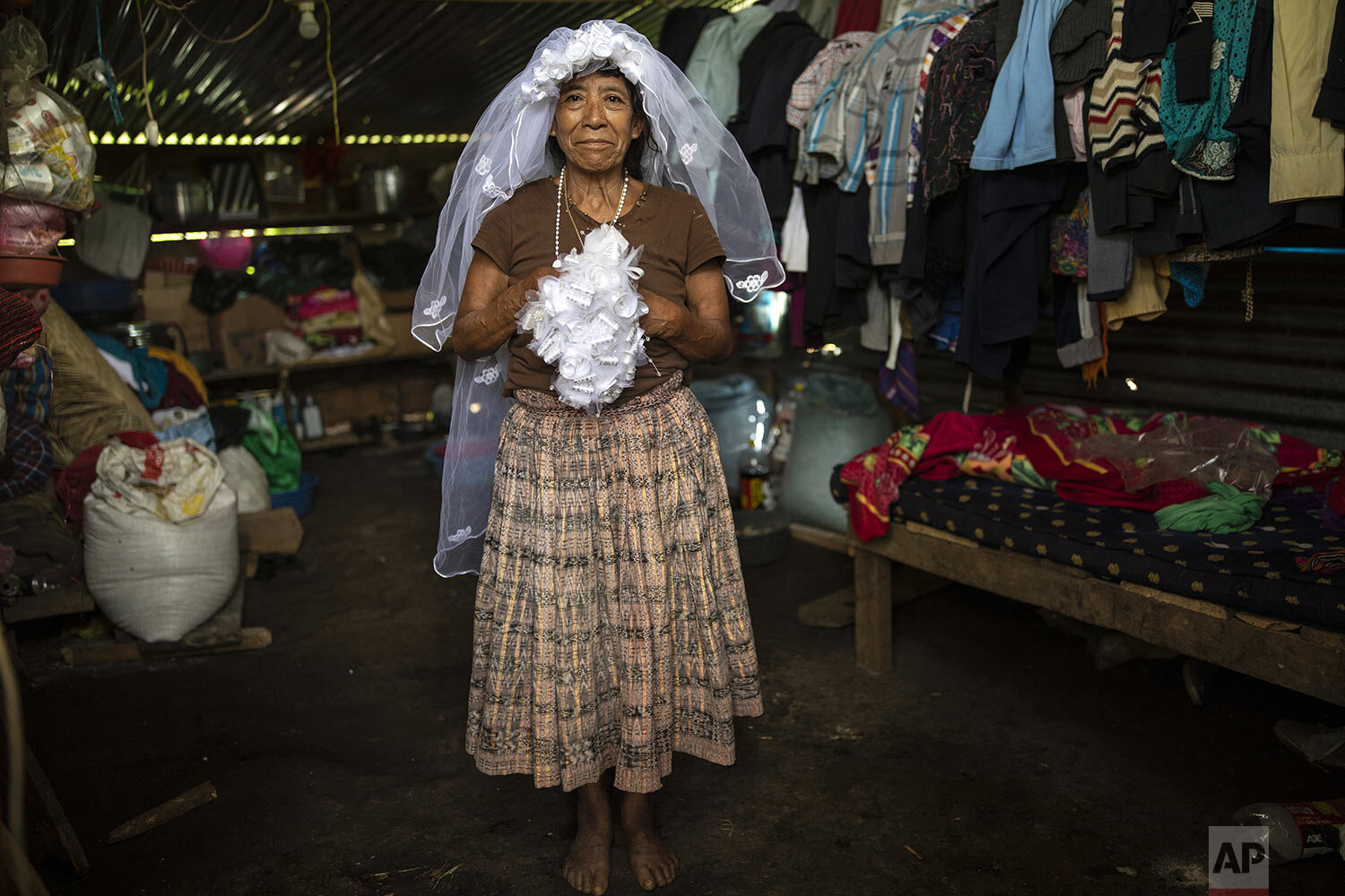  Rosario Cal poses for a photo wearing her veil and holding her bouquet, as she recalls her wedding day from this past May, in the new settlement Nuevo Queja, Guatemala, July 10, 2021. Cal is one of the survivors of a mudslide triggered by Hurricane 