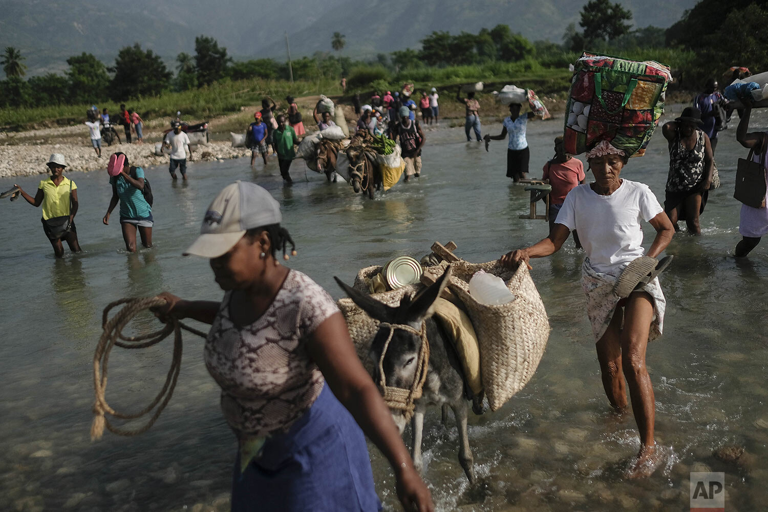  Residents cross the Cavaillon River to reach the Maniche market to sell their products, in Maniche, Haiti, Aug. 24, 2021, a week after a 7.2 magnitude earthquake. (AP Photo/Matias Delacroix) 