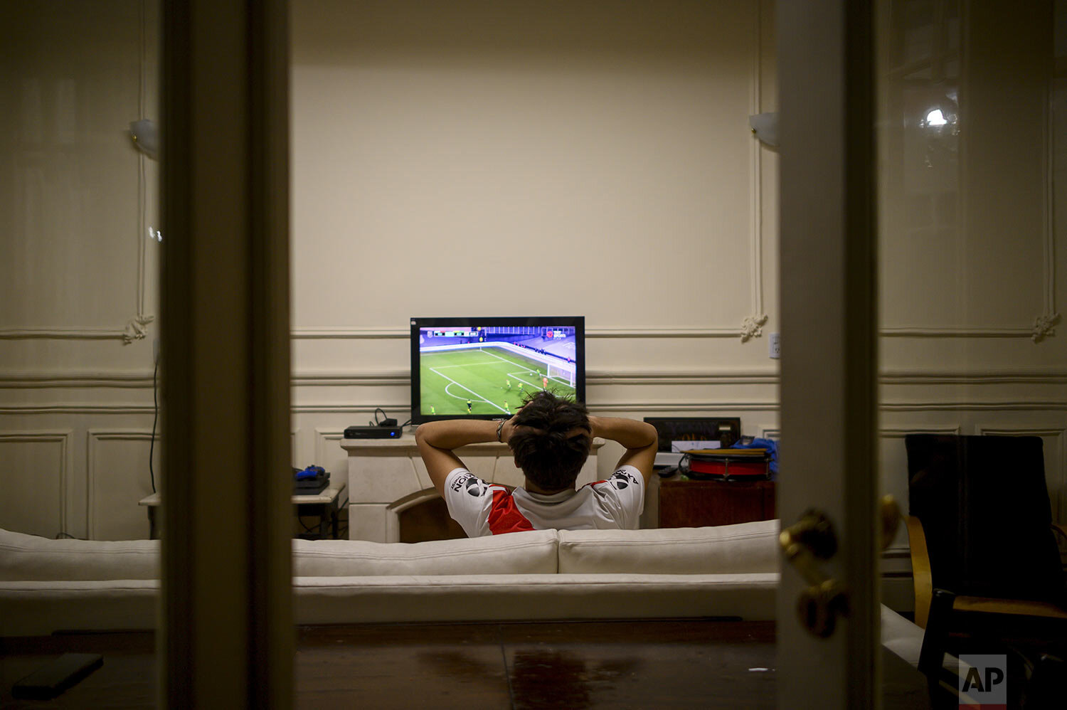  River Plate soccer fan Juan Camisassa watches his team play Club Atletico Aldosivi on television at his home during COVID-19 pandemic restrictions banning fans from stadiums in Buenos Aires, Argentina, Aug. 26, 2021. (AP Photo/Mario De Fina) 