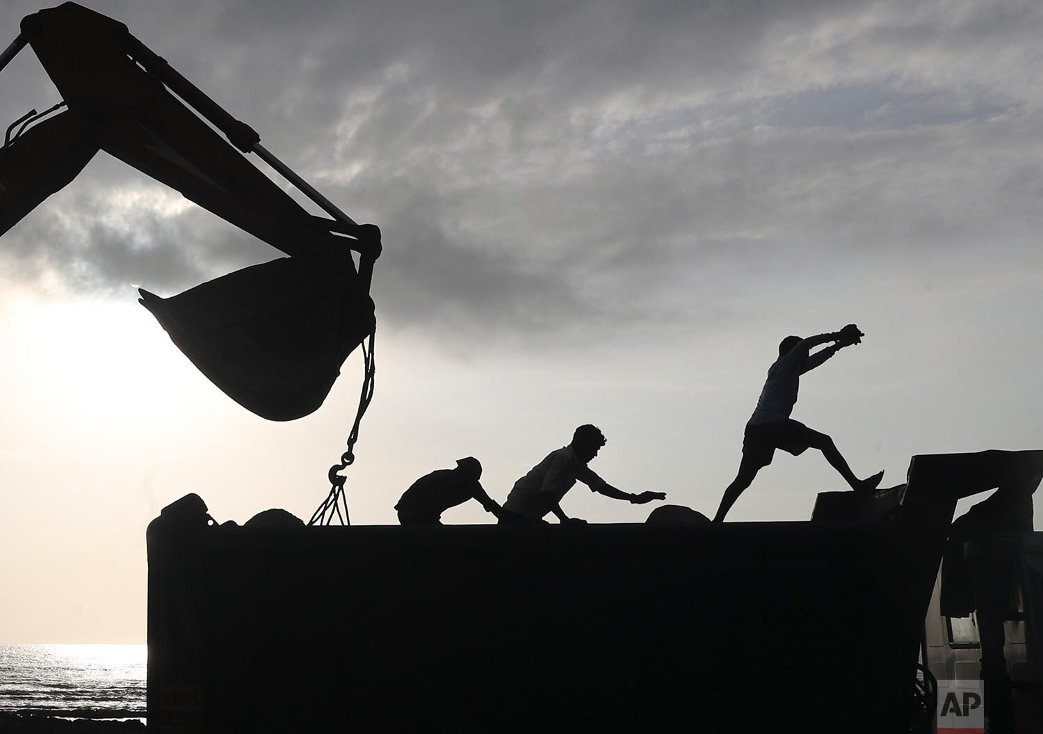  Workers use machinery at a coastal road project construction site in Mumbai, India, Thursday, Aug. 26, 2021. (AP Photo/Rafiq Maqbool) 
