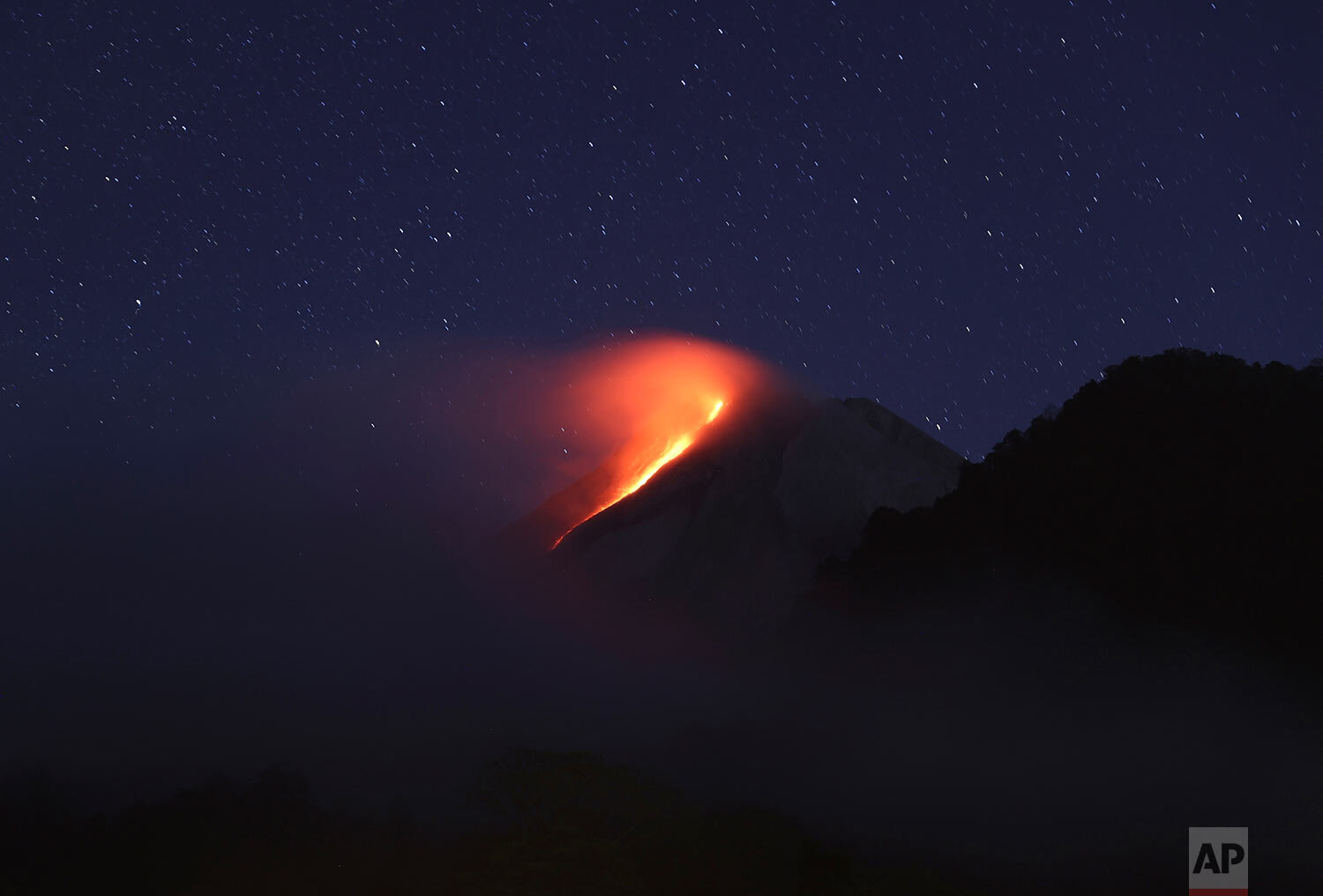  In this photo taken using slow camera shutter speed, hot lava runs down from the crater of Mount Merapi, in Sleman, Yogyakarta, Indonesia, early Wednesday, Aug. 11, 2021.  (AP Photo/Trisnadi) 