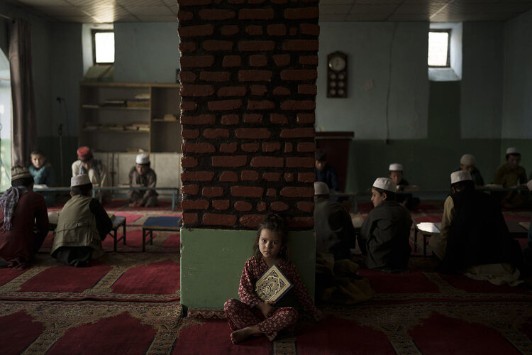 The niece of a teacher sits alone in a classroom as boys attend a class to memorize the Quran, Islam's holy book, at a madrasa in Kabul, Afghanistan, Tuesday, Sept. 28, 2021. (AP Photo/Felipe Dana)