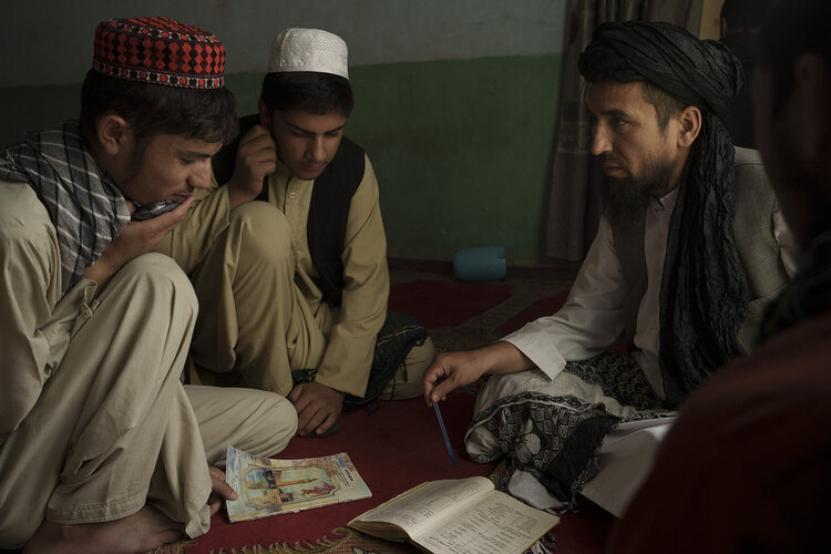Afghan madrasa director Sebghatullah Samadi, right, talks to students during class at a madrasa in Kabul, Afghanistan, Tuesday, Sept. 28, 2021. (AP Photo/Felipe Dana)