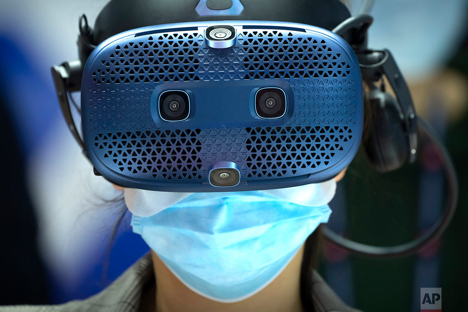  A woman wears a virtual reality headset as she takes a simulated bobsleigh ride at a booth for Chinese telecom provider China Unicom at the PT Expo in Beijing, Tuesday, Sept. 28, 2021. (AP Photo/Mark Schiefelbein) 