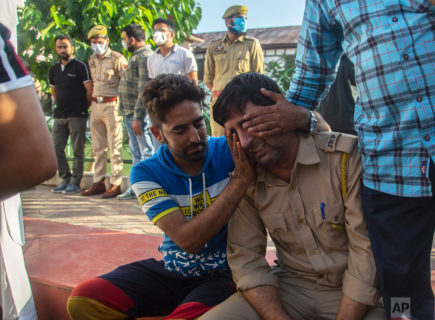  An Indian policeman is comforted as he weeps during a wreath laying ceremony of his colleague Arshad Mir in Srinagar, India, Sunday, Sept. 12, 2021.  (AP Photo/Mukhtar Khan) 