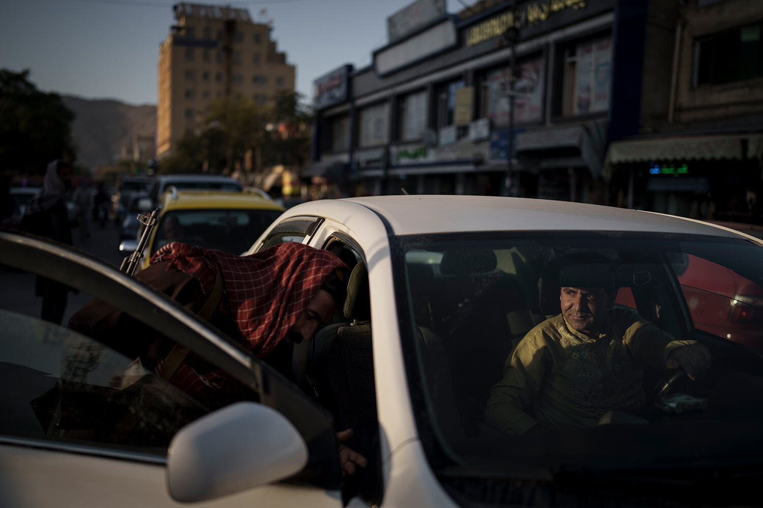  An afghan man looks as a Taliban fighter searches his car at a checkpoint in Kabul, Afghanistan, Tuesday, Sept. 14, 2021. (AP Photo/Felipe Dana)  