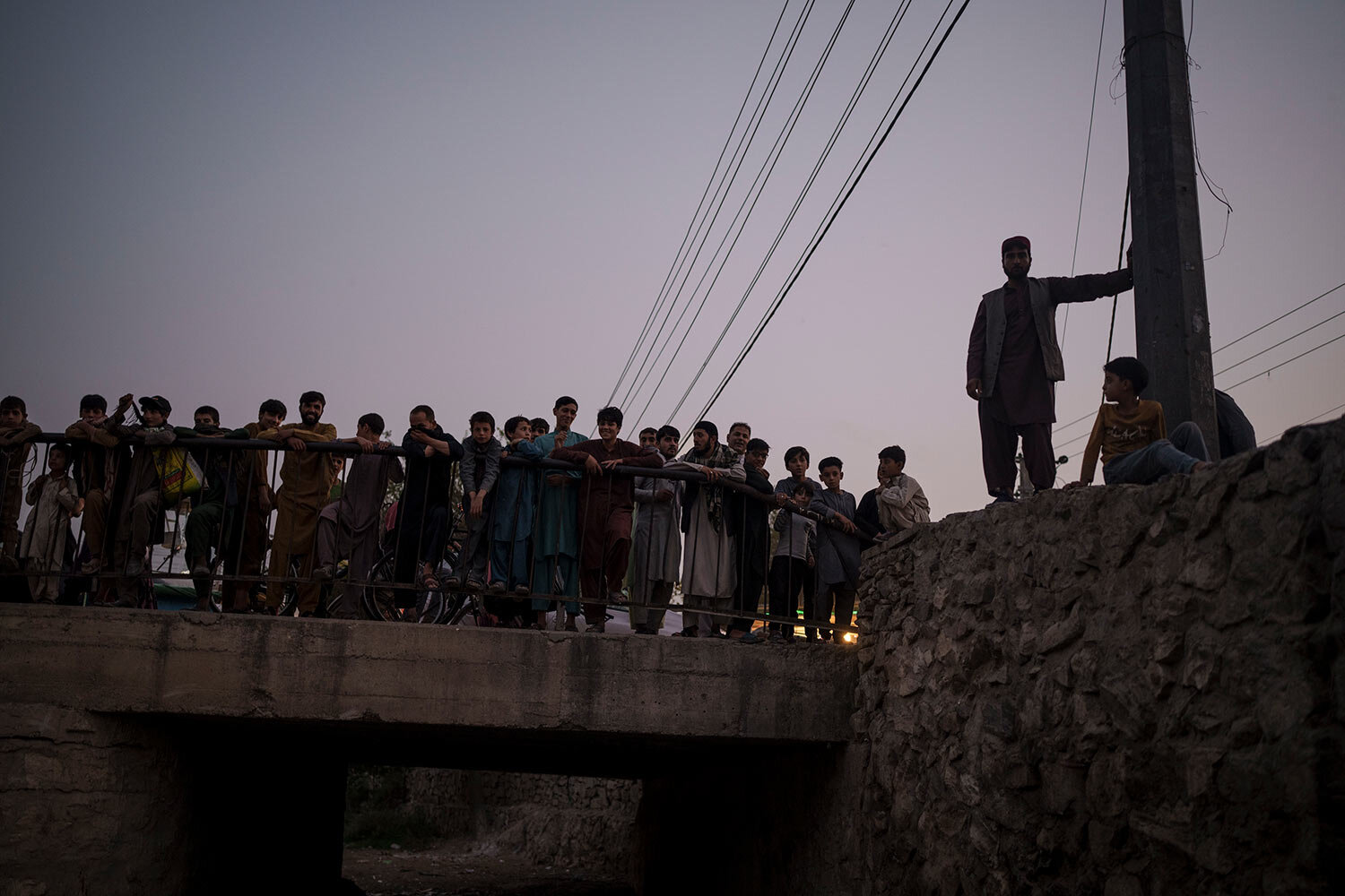  Afghans gather to watch Taliban fighters detaining drug users during a police operation in Kabul, Afghanistan, Friday, Oct. 1, 2021. (AP Photo/Felipe Dana)  