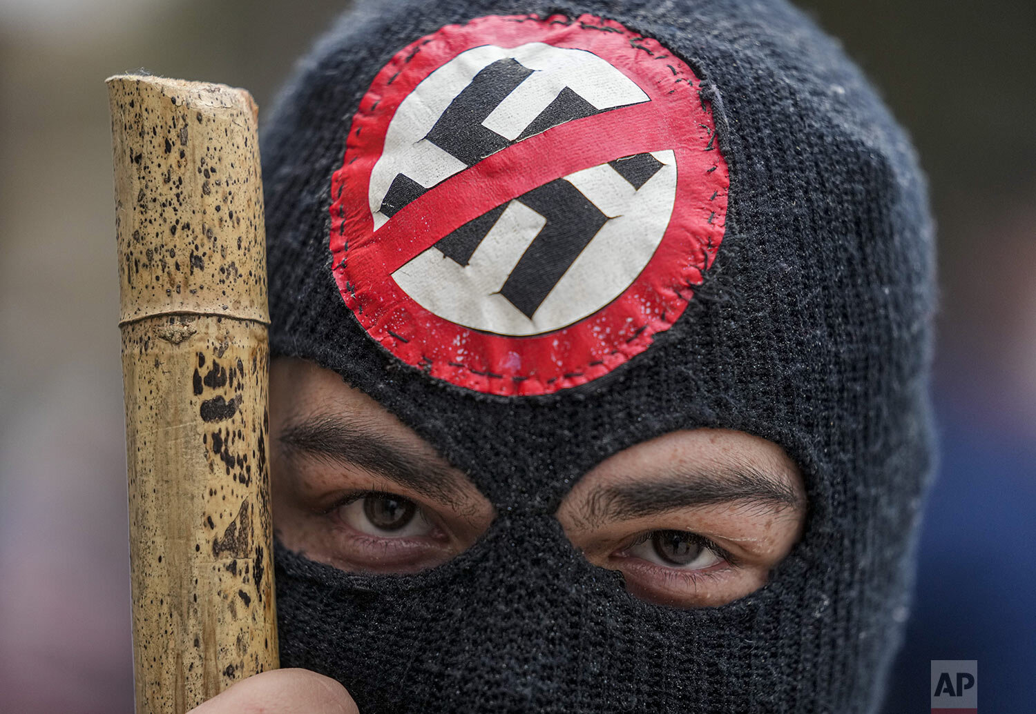  A protester wears an anti-Nazi symbol during protests on the anniversary of the 1973 military coup and the death of President Salvador Allende in Santiago, Chile, Sept. 11, 2021. The coup began the Pinochet dictatorship. (AP Photo/Esteban Felix) 