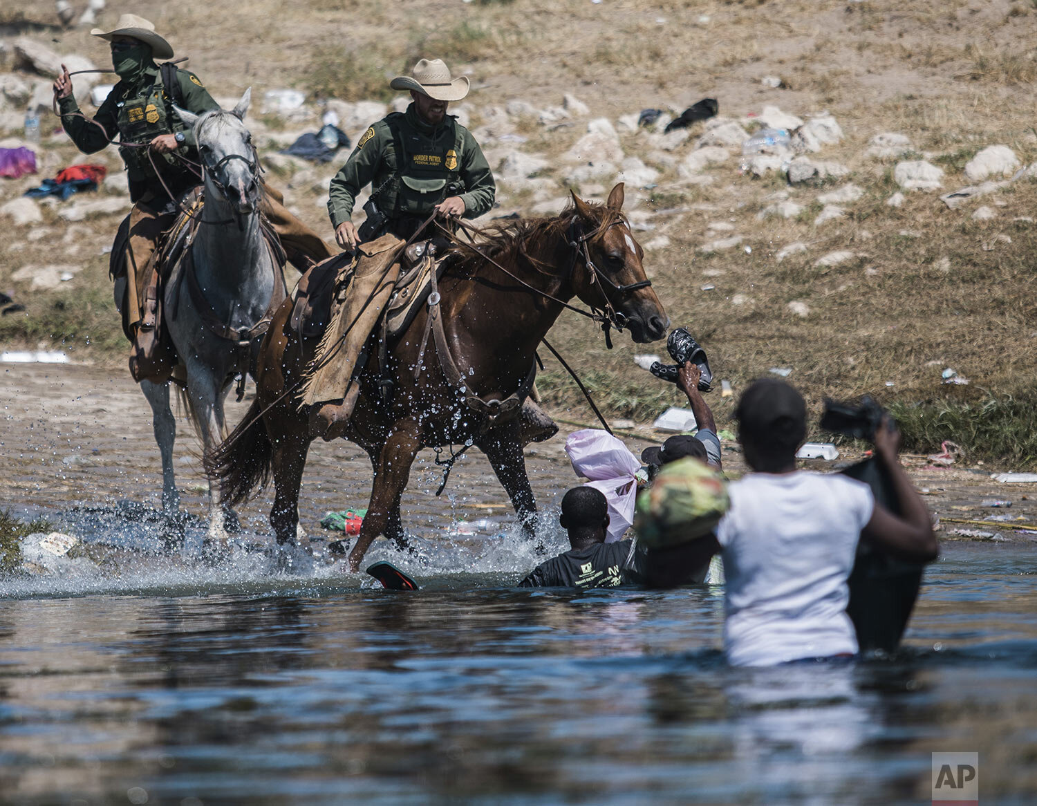  U.S. Customs and Border Protection mounted officers attempt to contain migrants as they cross the Rio Grande from Ciudad Acuña, Mexico, into Del Rio, Texas, Sept. 19, 2021. (AP Photo/Felix Marquez) 