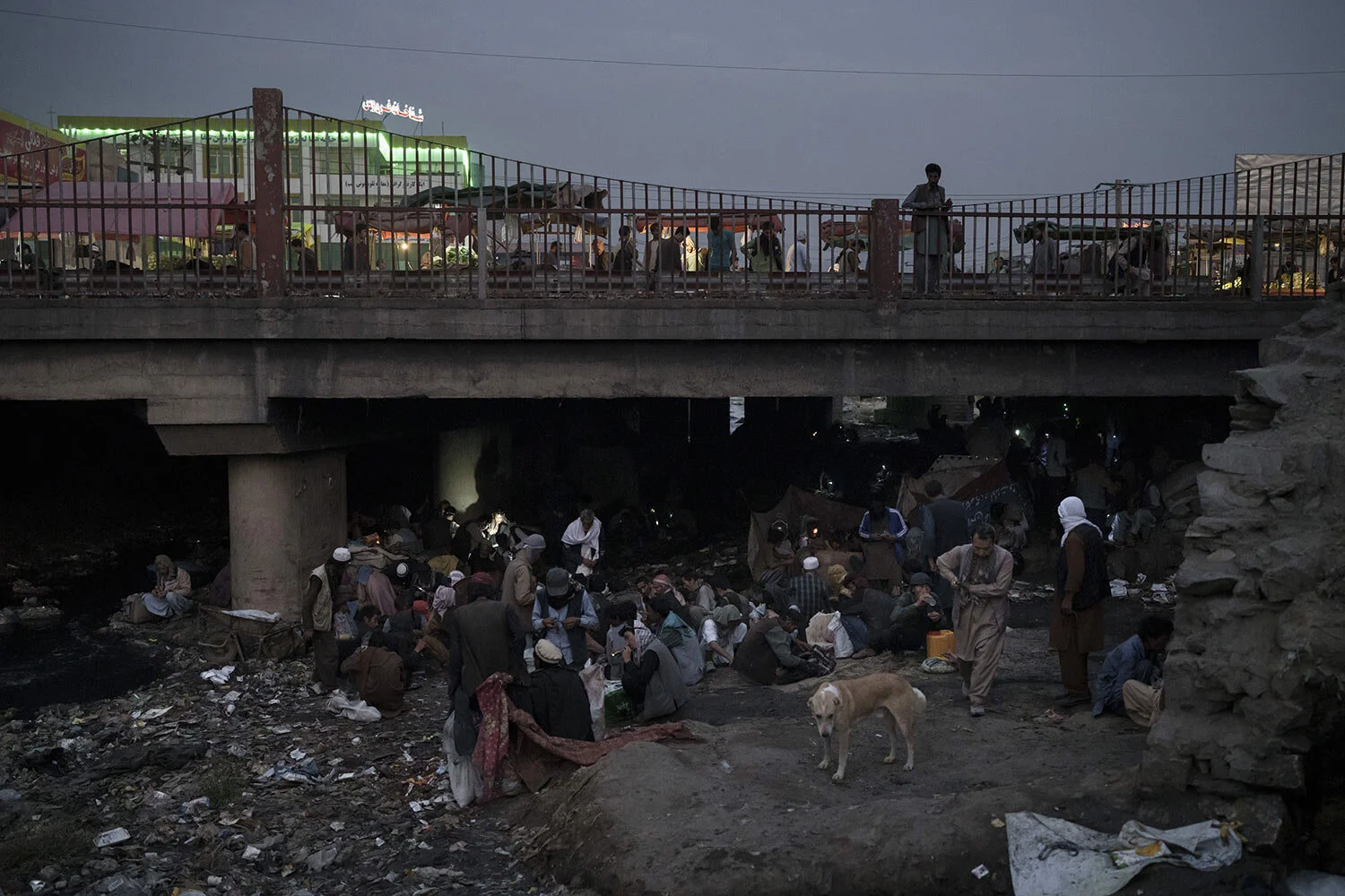 Afghánci se shromažďují pod mostem, aby ve čtvrtek 30. září 2021 konzumovali drogy, převážně heroin a metamfetaminy, v afghánském Kábulu. (AP Photo/Felipe Dana)