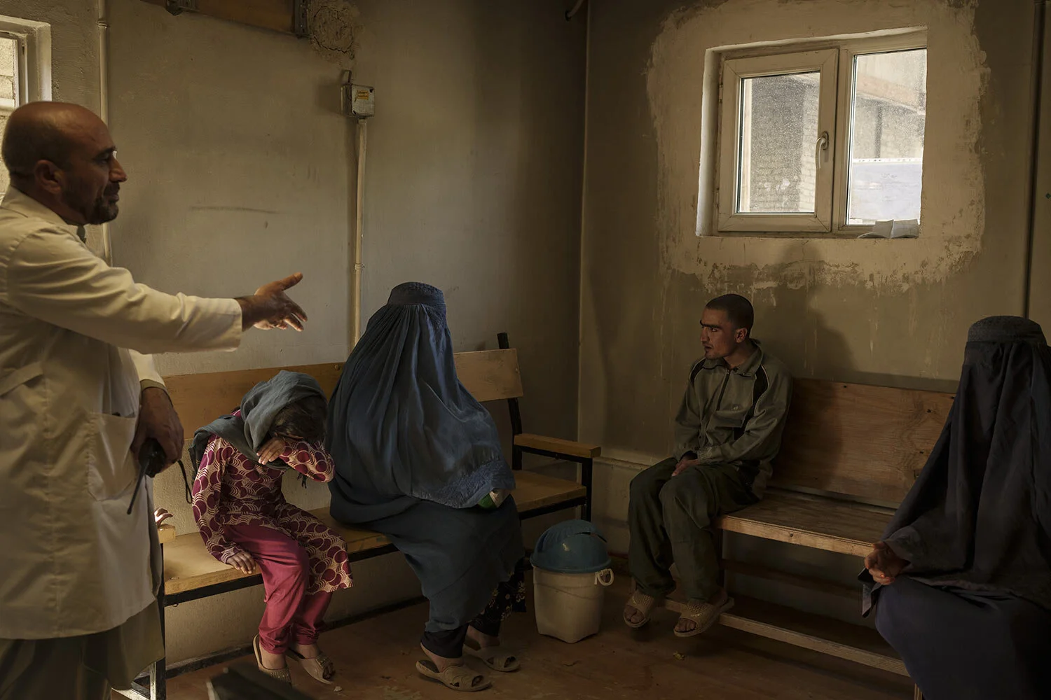 Dr. Wahedullah Koshan, vlevo, gestikuloval, když hovořil se střediskem Sitara poté, co se znovu sešla se svým 21letým synem, který byl během náletu Talibanu v Kábulu v Afghánistánu, pondělí, říjen, převezen do lékařské nemocnice Avicenna pro protidrogovou léčbu . 4, 2021. (AP Photo/Felipe Dana)