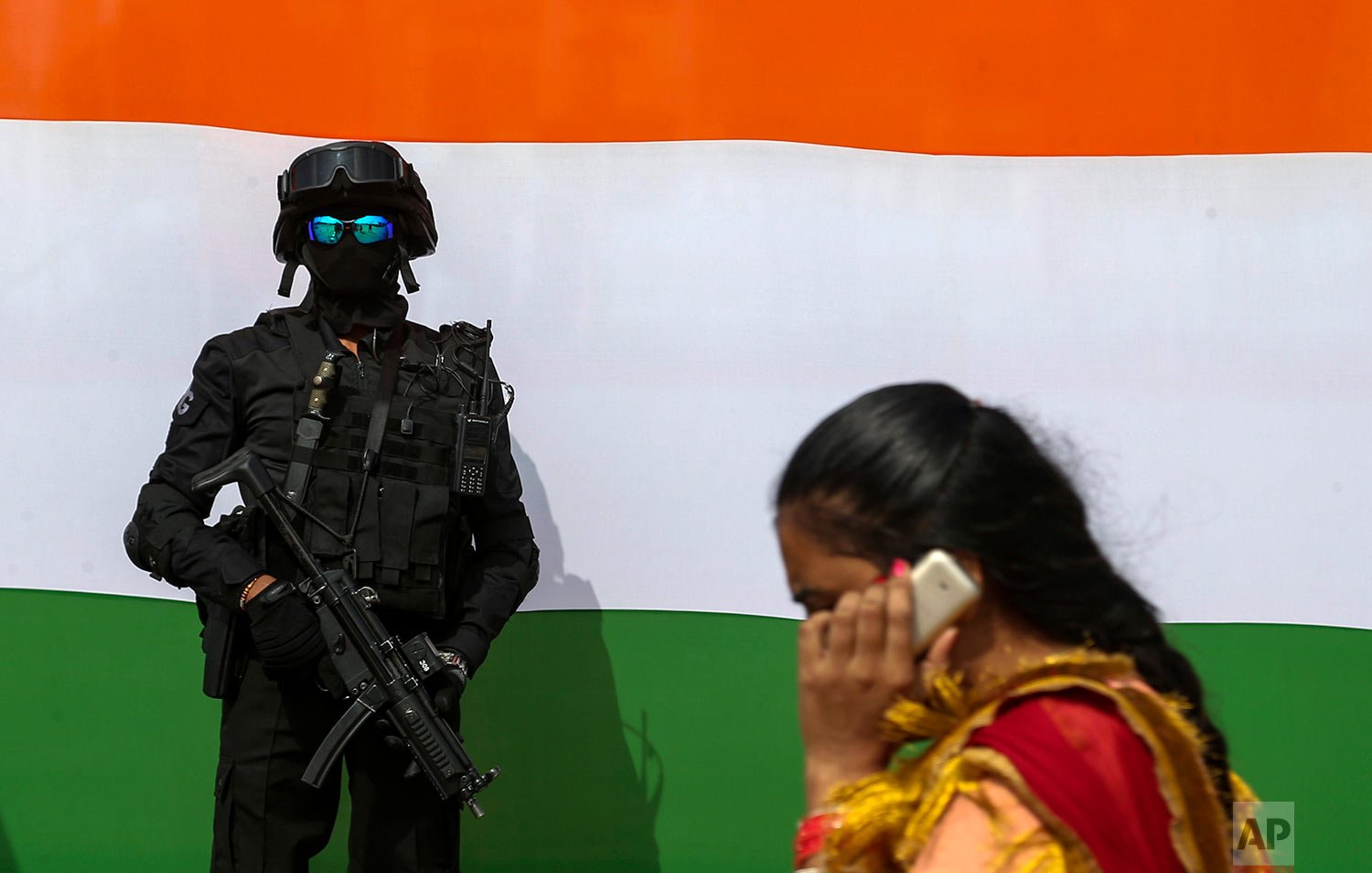 A National Security Guard (NSG) commando stands guard in front of the colors of Indian flag during a car rally of black cats held as part of celebrations marking 75 years of India’s Independence in Hyderabad, India, Sunday, Oct. 17, 2021. (AP Photo/
