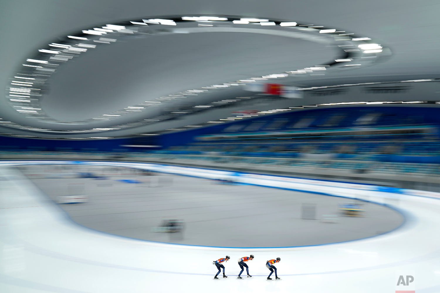  In this photo taken with a long shutter speed, members of the Netherlands team compete in the men's pursuit during the Speed Skating China Open, a test event for the 2022 Winter Olympics, at the National Speed Skating Oval in Beijing, Saturday, Oct.