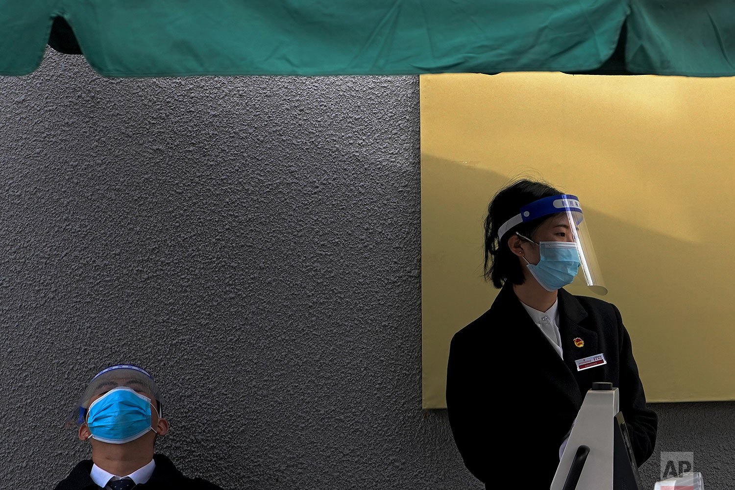  Workers wearing face masks and shields to help curb the spread of the coronavirus wait for visitors outside a museum in Beijing, Thursday, Oct. 28, 2021. (AP Photo/Andy Wong) 