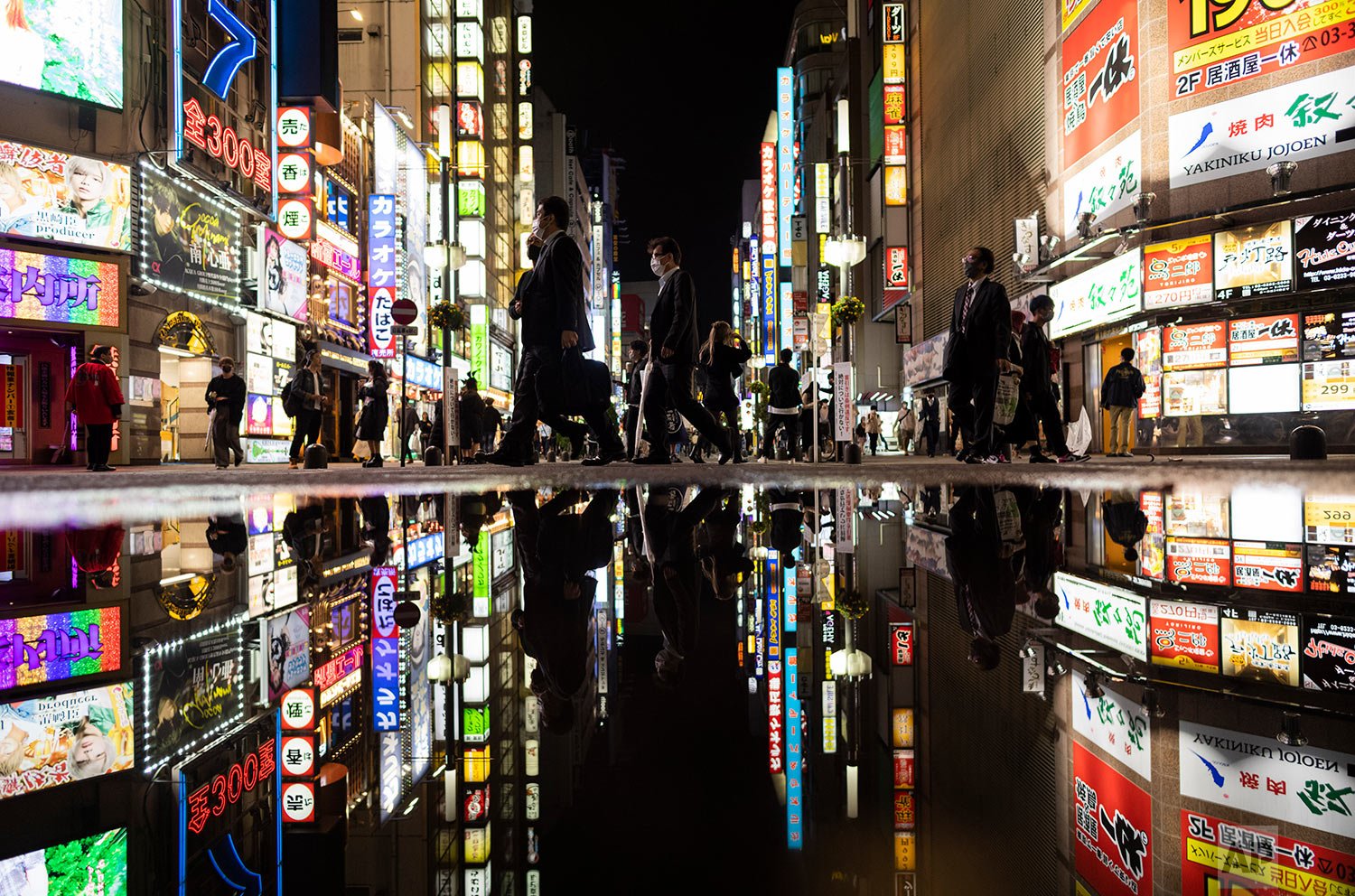  People walk through the famed Kabukicho entertainment district of Tokyo on the first night of the government's lifting of a coronavirus state of emergency Friday, Oct. 1, 2021. (AP Photo/Hiro Komae) 