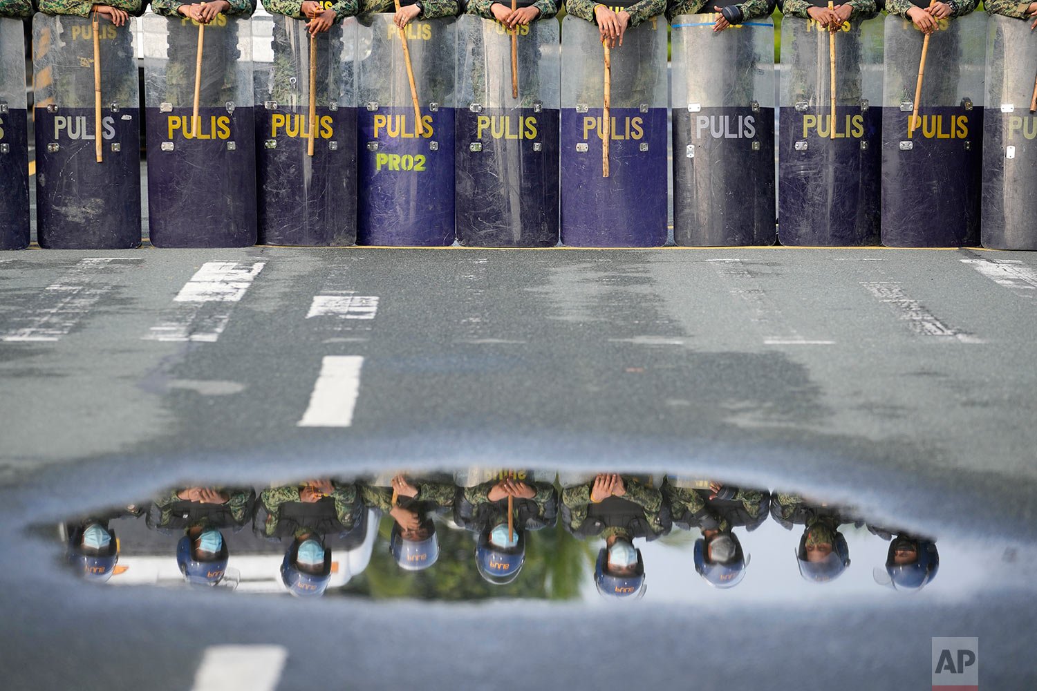  Police are reflected on water as they secure the area where politicians will file their certificate of candidacy before the Commission on Elections on Friday, Oct. 1, 2021 in Manila, Philippines. (AP Photo/Aaron Favila) 