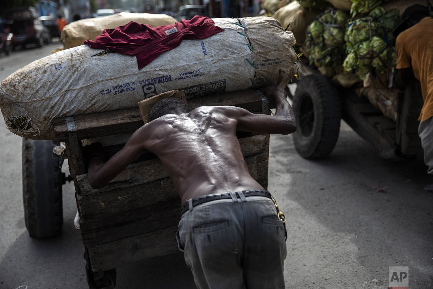  A porter pushes a loaded cart from the Croix de Bossales food market in downtown Port-au-Prince, Haiti, Oct. 4, 2021. (AP Photo/Rodrigo Abd) 