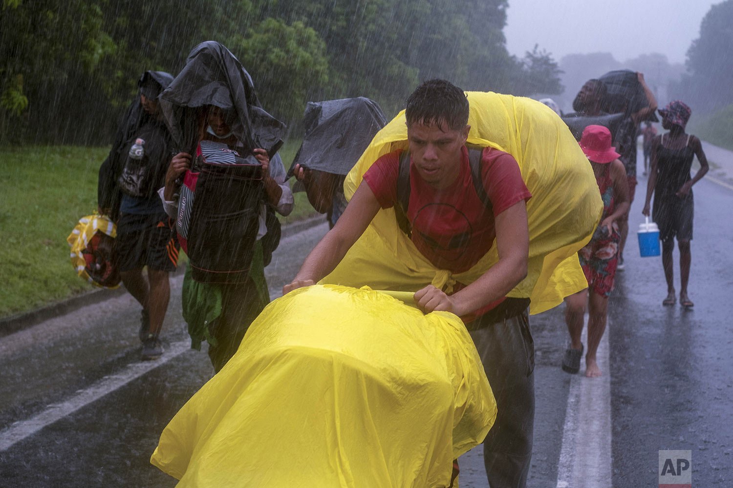  Migrants walk under the rain along a highway from Acacoyahua to Uluapan, Chiapas state, on Mexico’s southern border, Oct. 29, 2021, as they continue their journey north toward the U.S. (AP Photo/Isabel Mateos) 