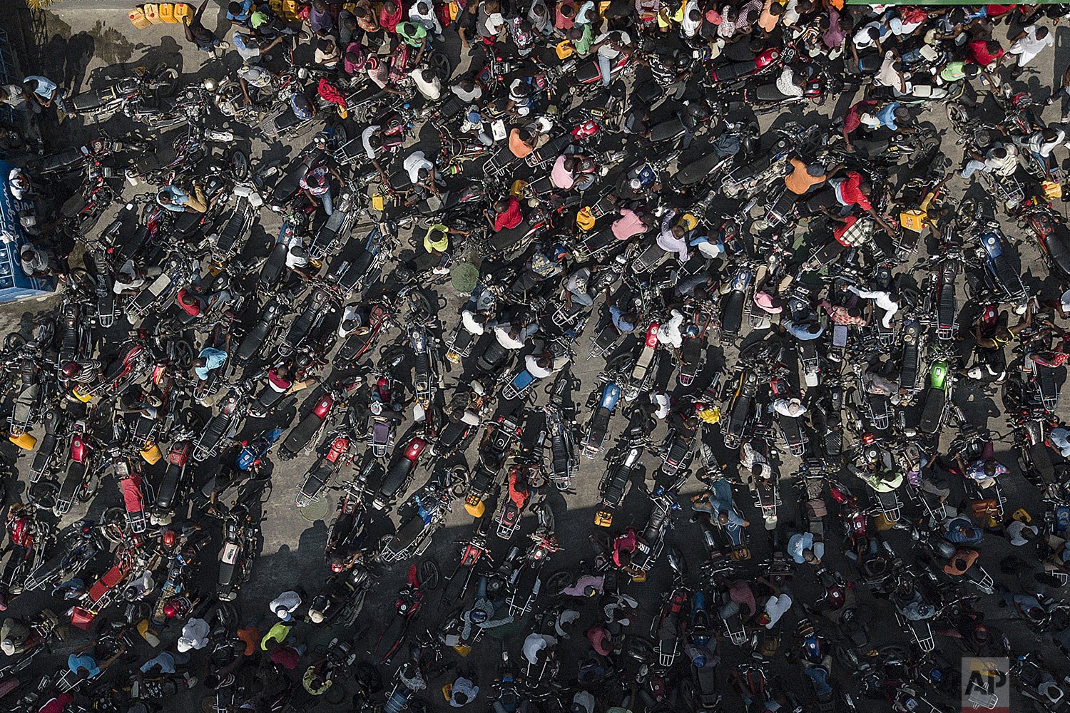  Motorycyclists crowd a gas station in hopes of filling up their tanks during a national fuel shortage in Port-au-Prince, Haiti, Oct. 31, 2021. (AP Photo/Matias Delacroix) 