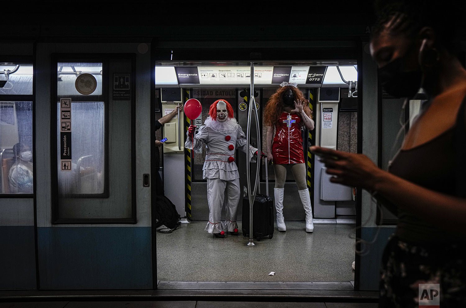  People in Halloween costumes travel on the subway in Santiago, Chile, Oct. 31, 2021. (AP Photo/Esteban Felix) 