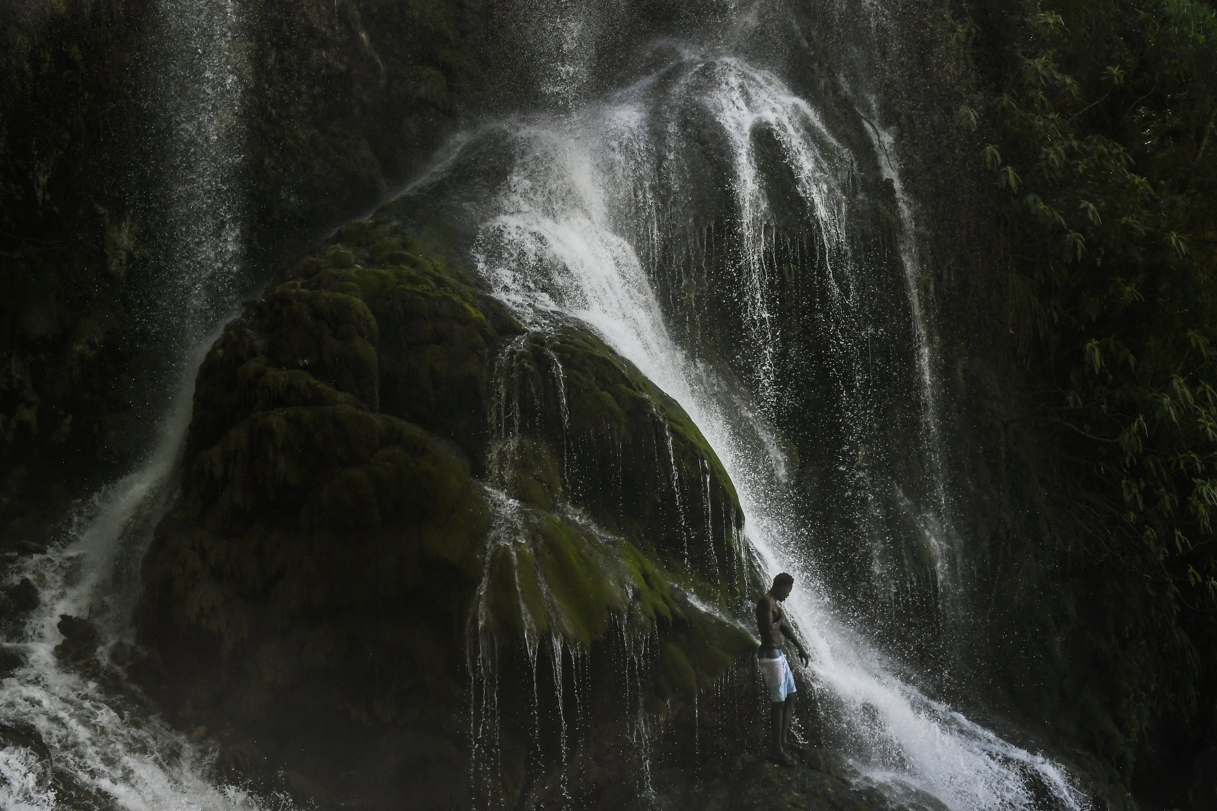  A voodoo pilgrim bathes in a waterfall believed to have purifying powers during an annual celebration in Saut d' Eau, Haiti, on July 16, 2021. (AP Photo/Matias Delacroix) 