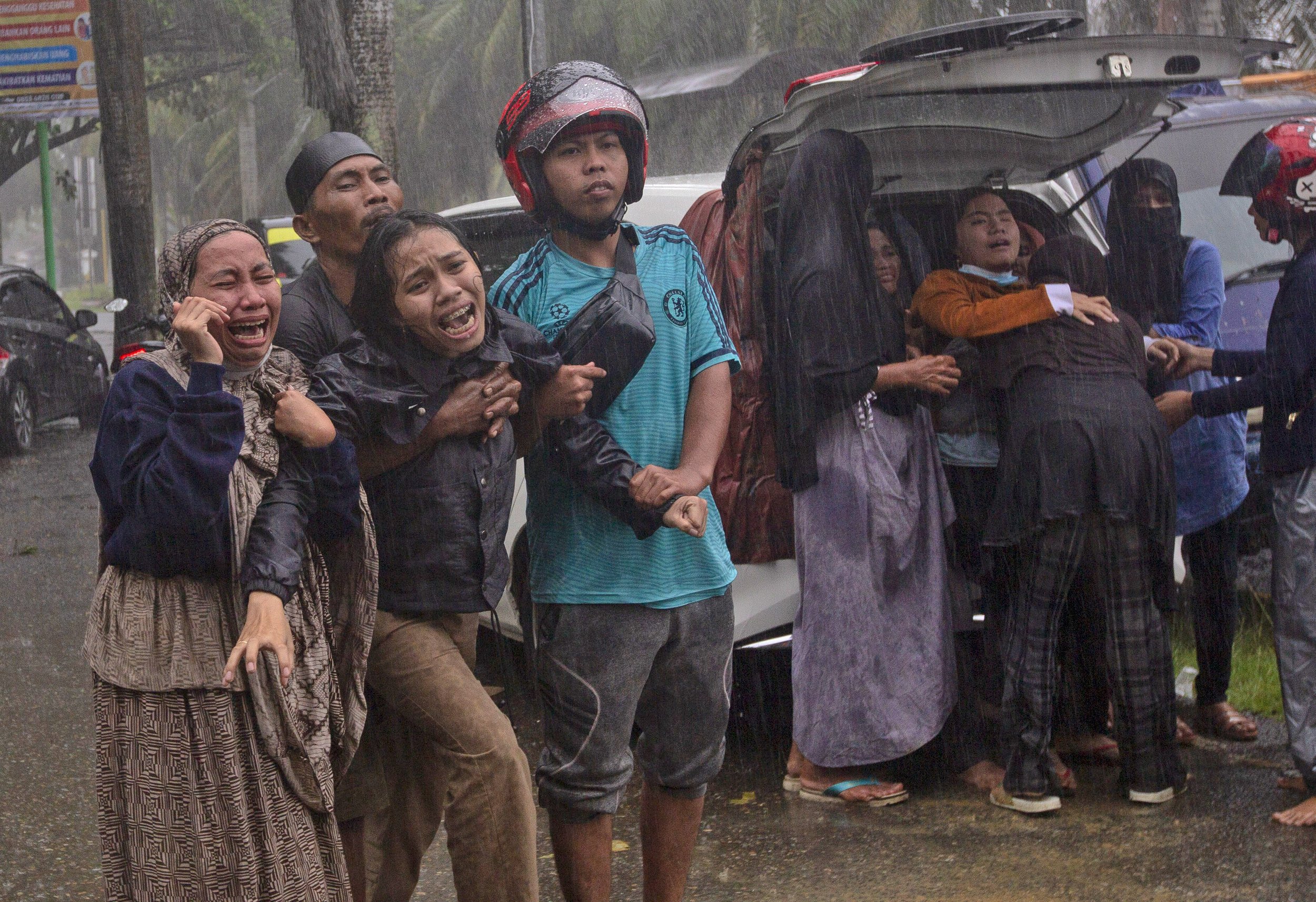  People react as the body of a relative is recovered from the rubble of a building at an area damaged by an earthquake in Mamuju, West Sulawesi, Indonesia, on Jan. 15, 2021. (AP Photo/Yusuf Wahil) 