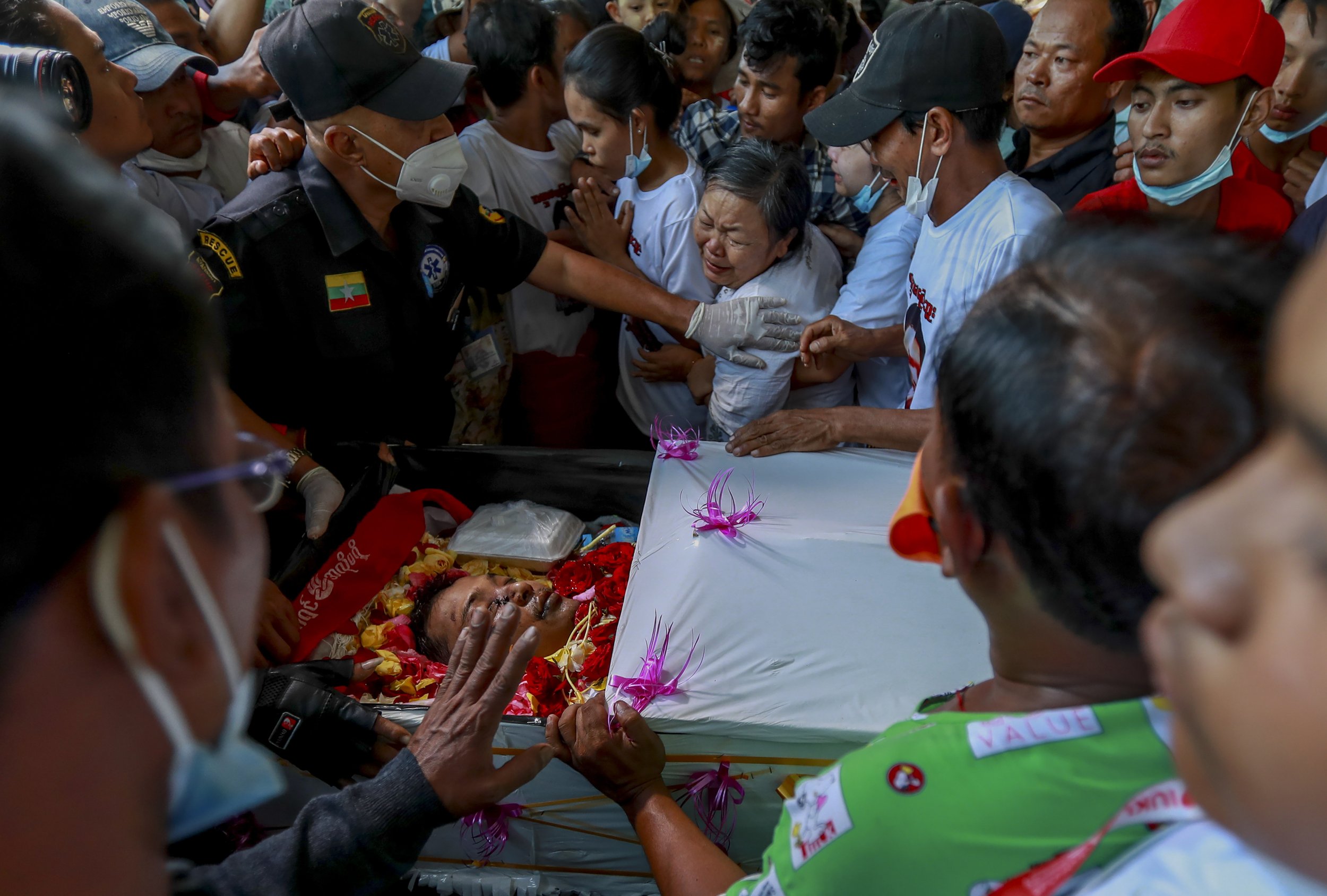  Tin Tin Win, center, weeps over the body of her son, Tin Htut Hein, at his funeral in Yangon, Myanmar, on Feb. 24, 2021. Tin Htut Hein was shot four days earlier while acting as a volunteer guard for a neighborhood watch group that was set up over f