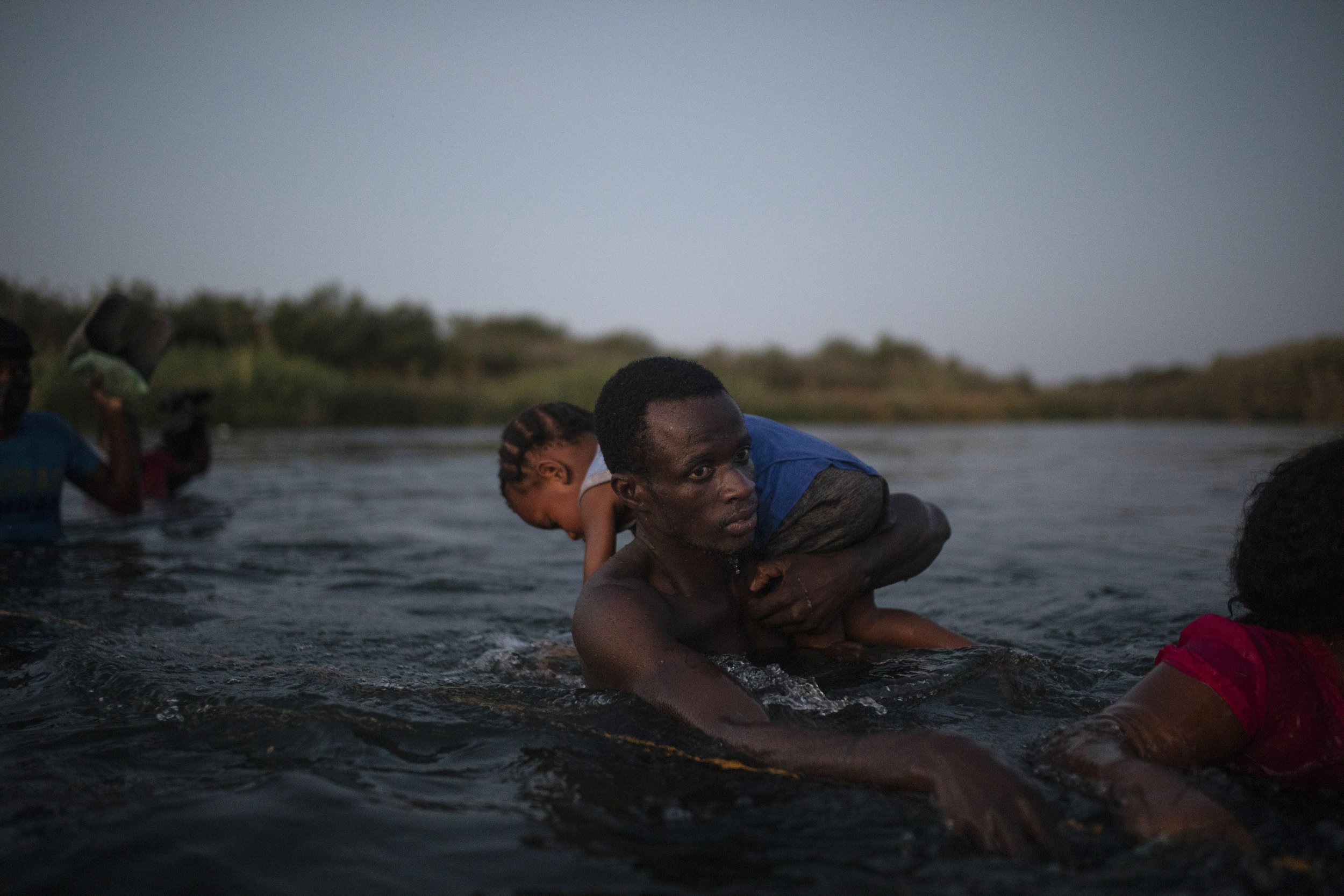  Haitian migrants wade across the Rio Grande from Del Rio, Texas, to Ciudad Acuña, Mexico, on Sept. 19, 2021, to avoid deportation ​to Haiti from the U.S. (AP Photo/Felix Marquez) 