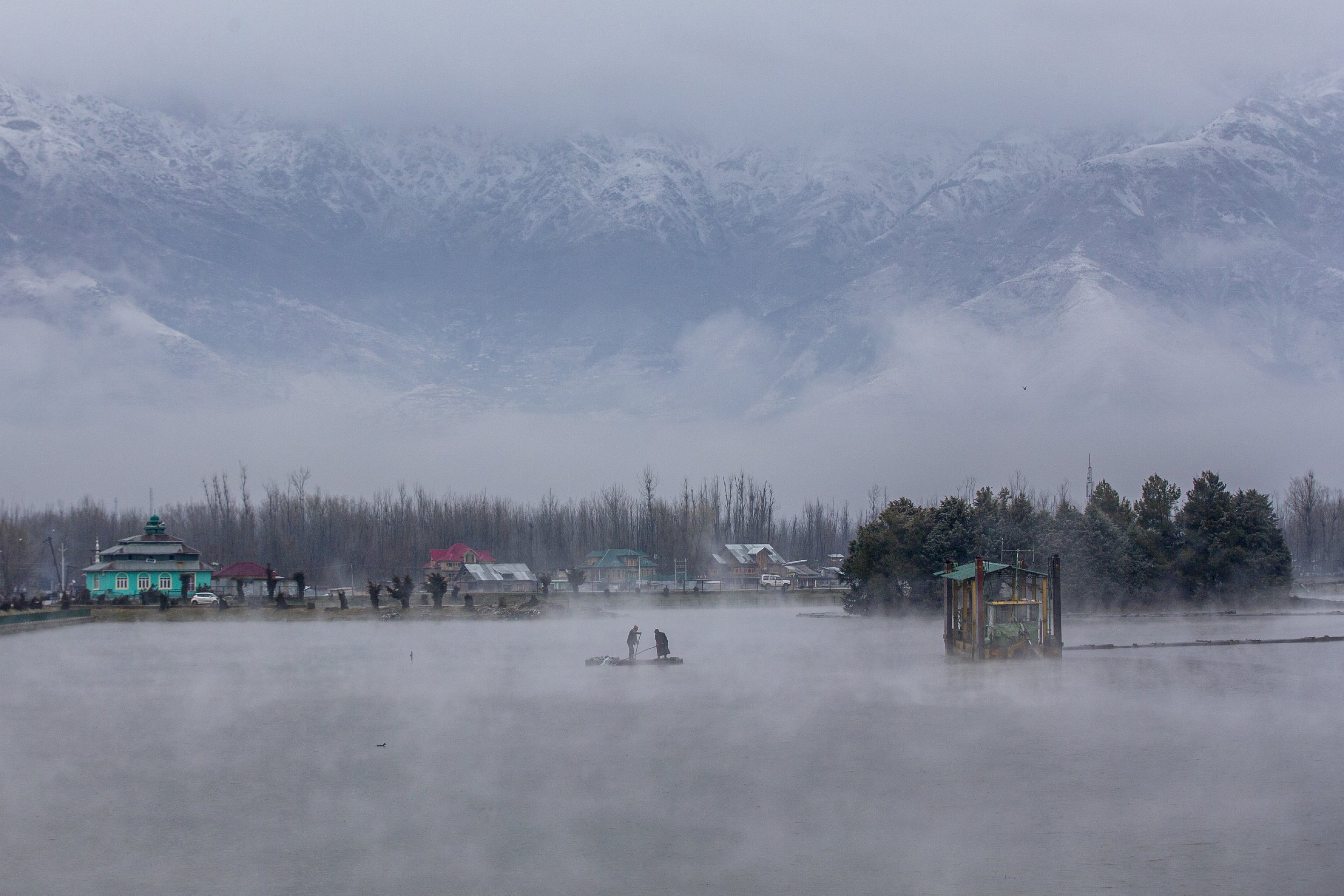  Kashmiri men row their raft made of plastic pipes on Dal Lake on the outskirts of Srinagar, Indian controlled Kashmir, after a brief spell of fresh snowfall, on Feb. 27, 2021. (AP Photo/Dar Yasin) 