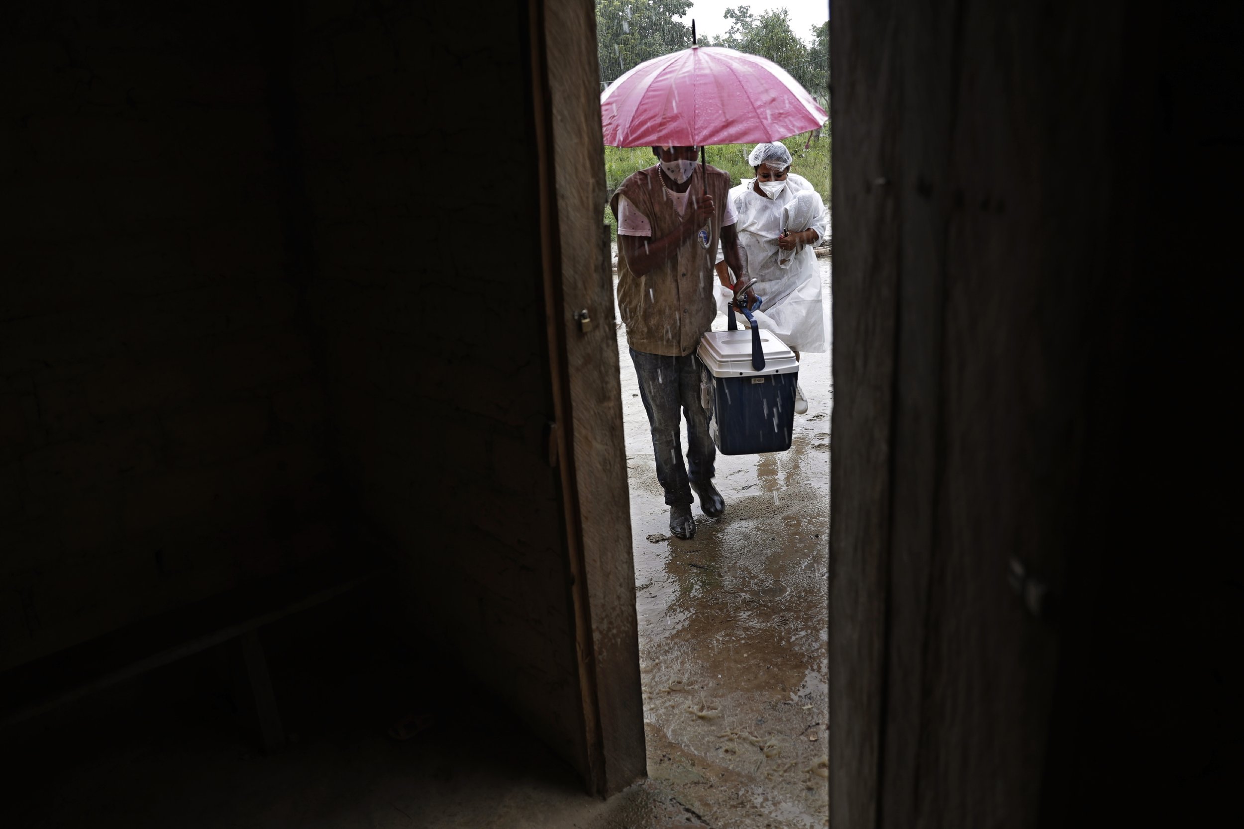  Health workers arrive with a cooler containing doses of the Sinovac vaccine at a home in the Kalunga Vao de Almas community, a rural area on the outskirts of Cavalcante, Goias state, Brazil, on March 15, 2021. Kalunga Vao de Almas is a traditional c
