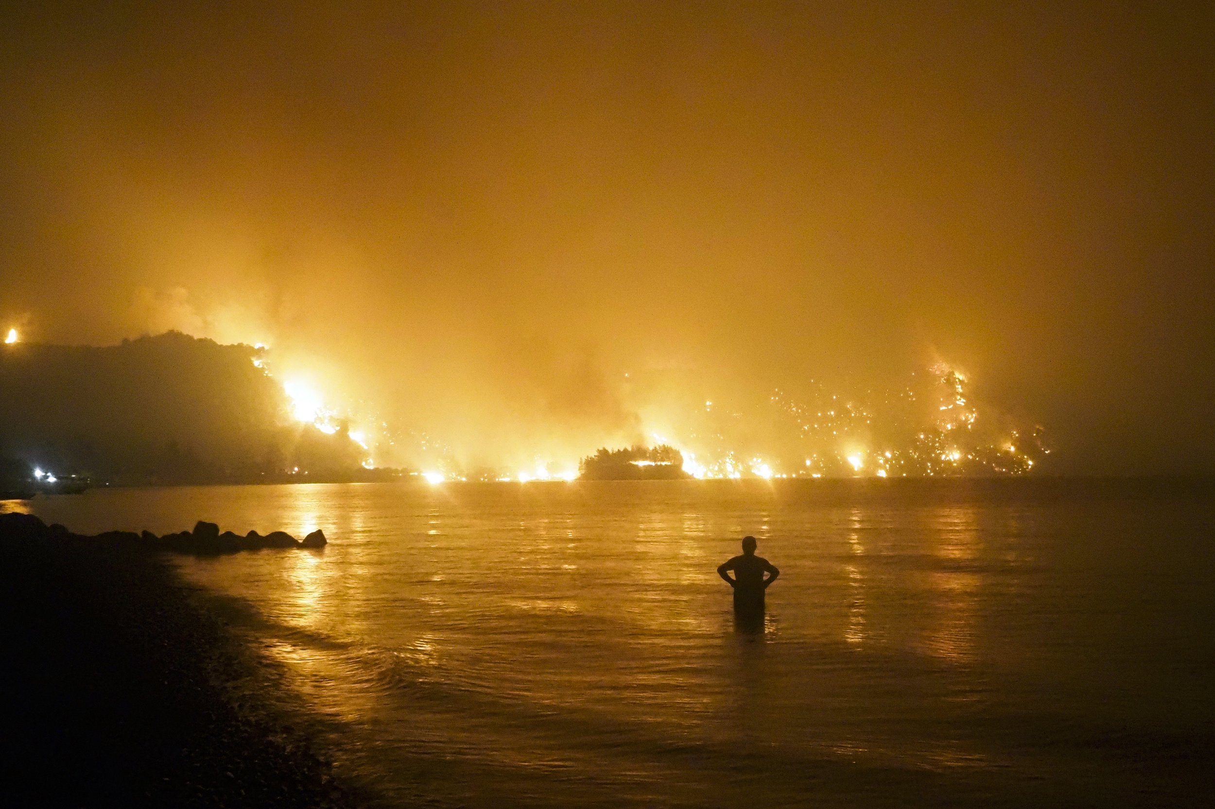  A man watches as a wildfire approaches Kochyli beach near the village of Limni, Greece, about 160 kilometers (100 miles) north of Athens, on Aug. 6, 2021. (AP Photo/Thodoris Nikolaou) 