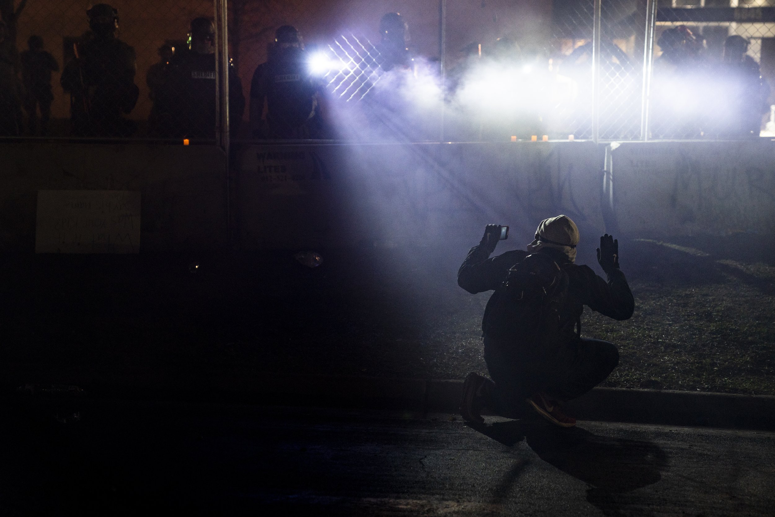  Police shine lights on a demonstrator with raised hands during a protest outside the Brooklyn Center Police Department in Brooklyn Center, Minn., on April 14, 2021, over the fatal shooting of Daunte Wright, a Black man, by a white police officer dur