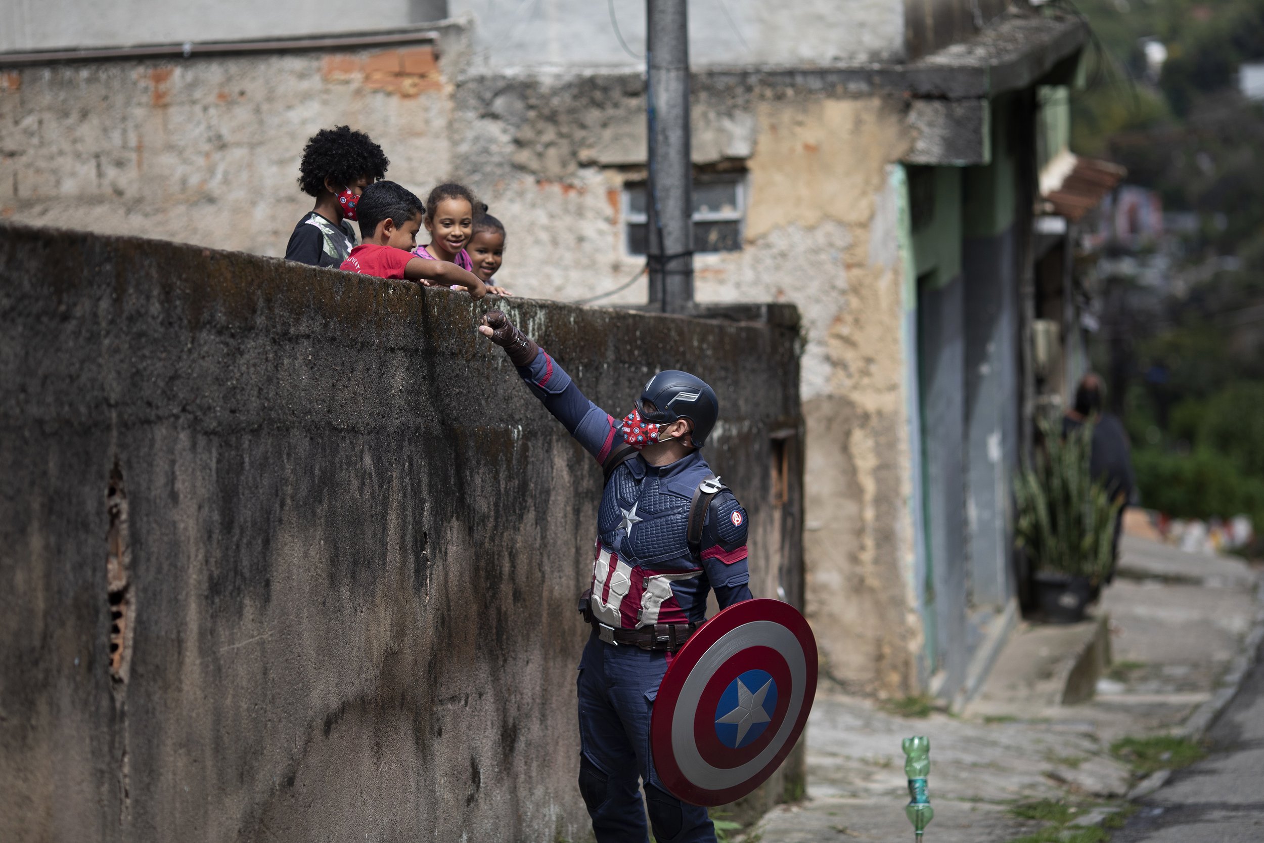  Military police officer Everaldo Pinto, dressed as superhero Captain America, greets children and encourages them to protect themselves during the COVID-19 pandemic in Petropolis, Rio de Janeiro state, Brazil, on April 15, 2021. (AP Photo/Silvia Izq