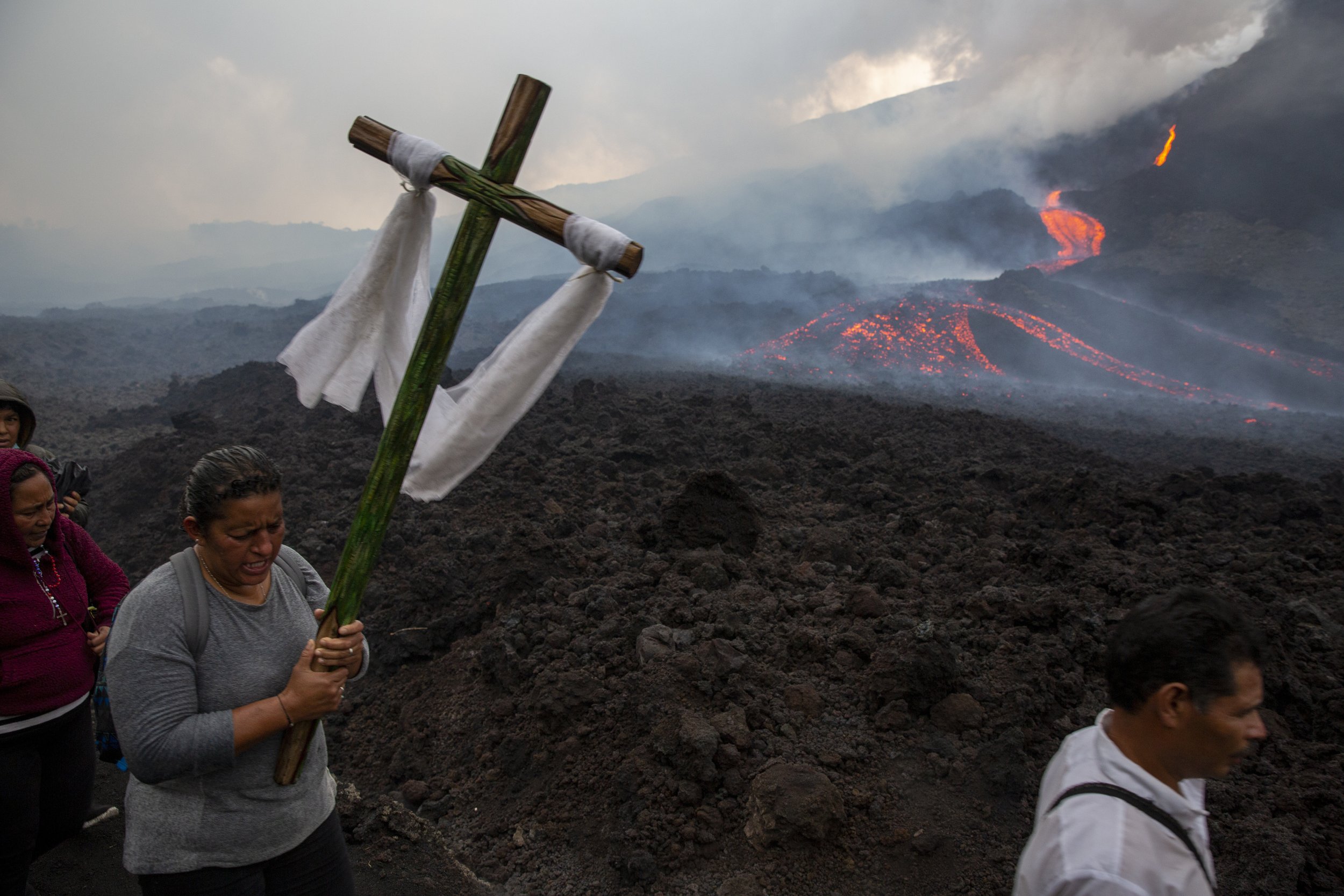  A woman carries a wooden cross during a pilgrimage to pray that the Pacaya volcano decreases its activity, in San Vicente Pacaya, Guatemala, on May 5, 2021. The volcano, just 50 kilometers (31 miles) south of Guatemala's capital, became more active 