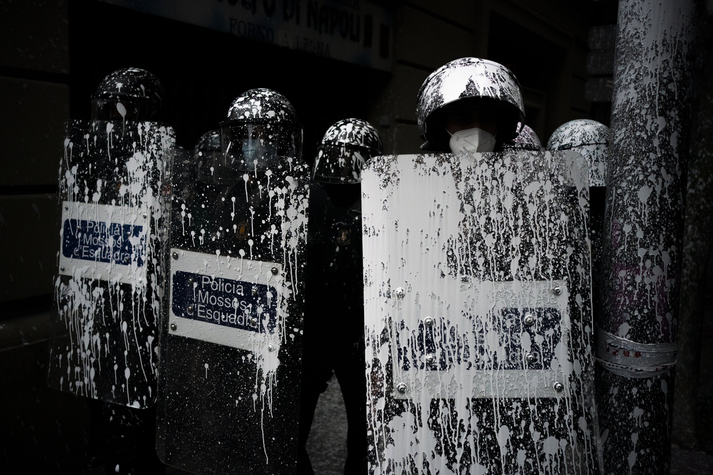  Riot police officers covered by paint thrown by protesters stand guard as activists try to stop the eviction of Axel Altadill from his apartment in Barcelona, Spain, on May 25, 2021. Altadill has been accused of squatting in the apartment since Janu