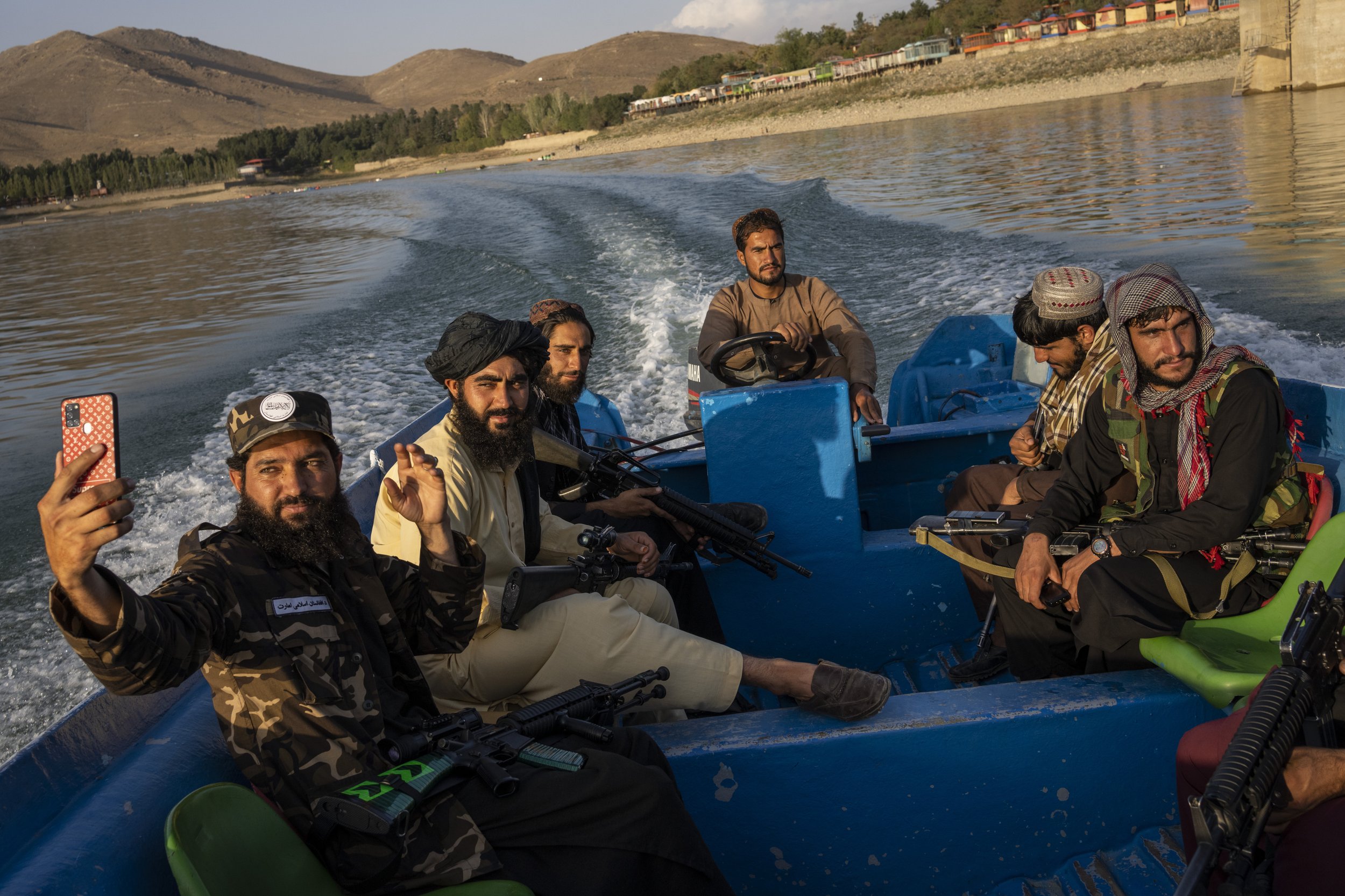  Taliban fighters ride in a boat in the Qargha dam outside Kabul, Afghanistan, on Sept. 24, 2021. (AP Photo/Bernat Armangue) 
