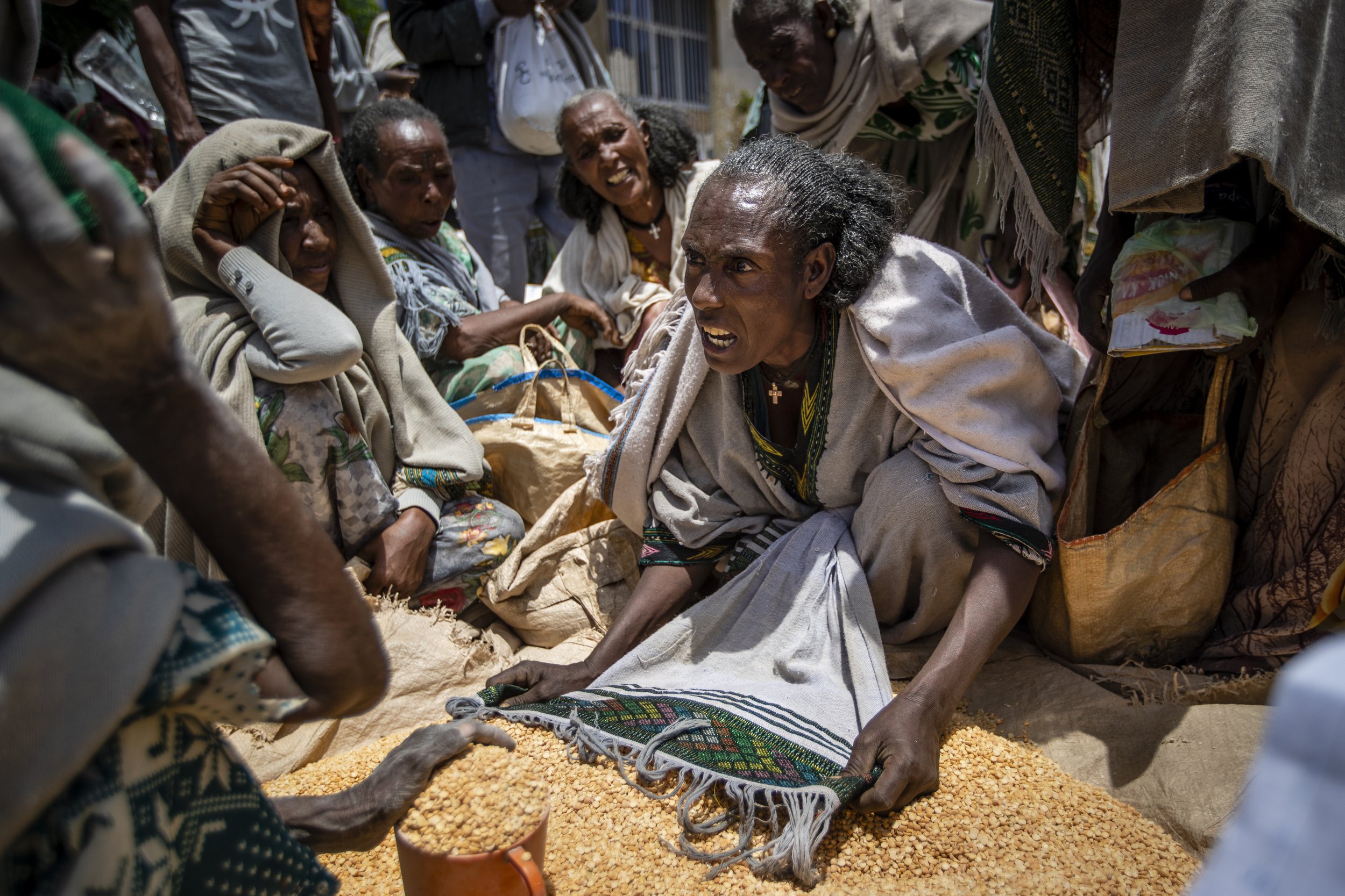  An Ethiopian woman argues with others over the allocation of yellow split peas distributed by the Relief Society of Tigray in the town of Agula, in the Tigray region of northern Ethiopia, on May 8, 2021. In war-torn Tigray, it is not just that peopl