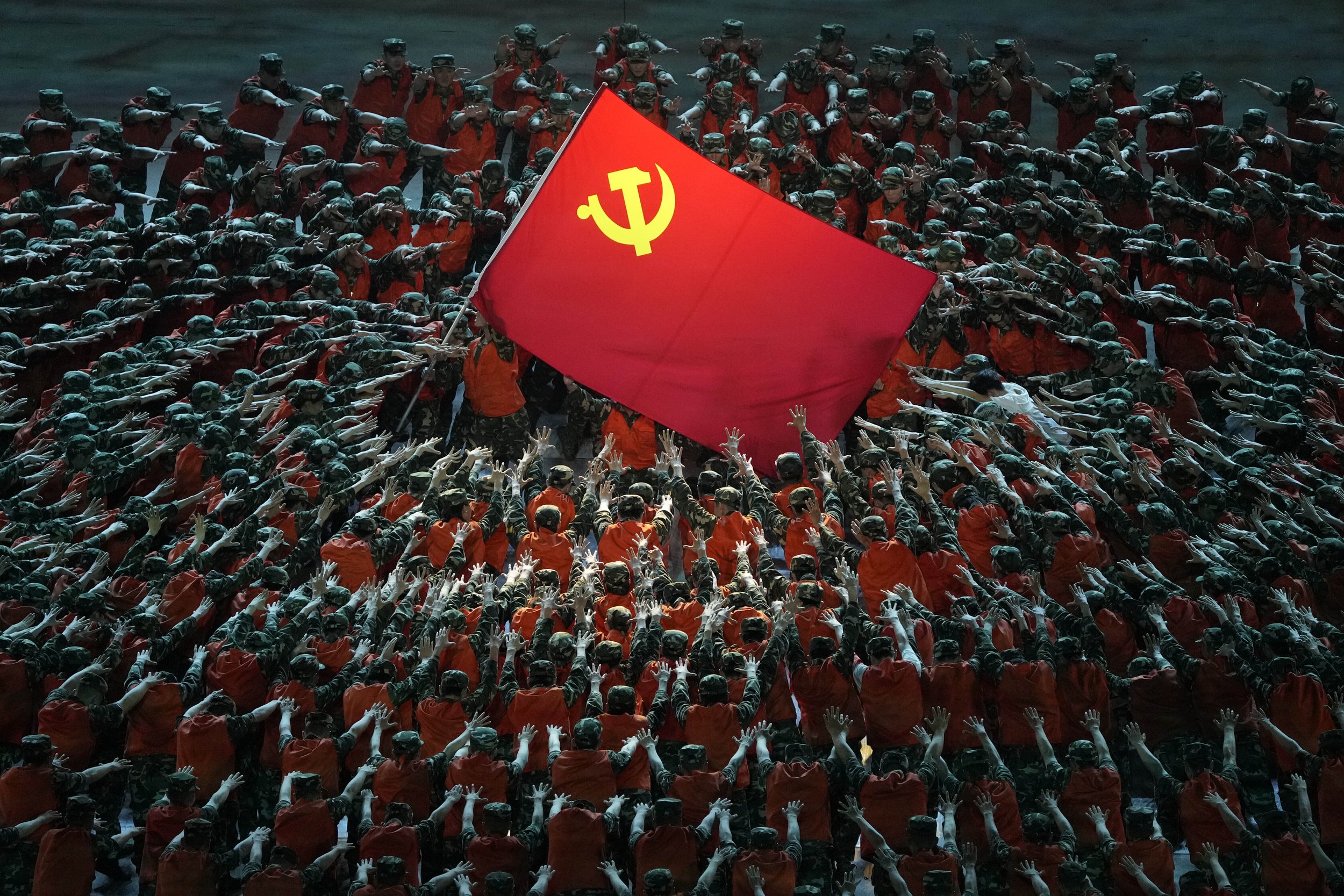  Performers dressed as rescue workers gather around the Communist Party flag during a gala show ahead of the 100th anniversary of the founding of the Chinese Communist Party in Beijing, on June 28, 2021. (AP Photo/Ng Han Guan) 
