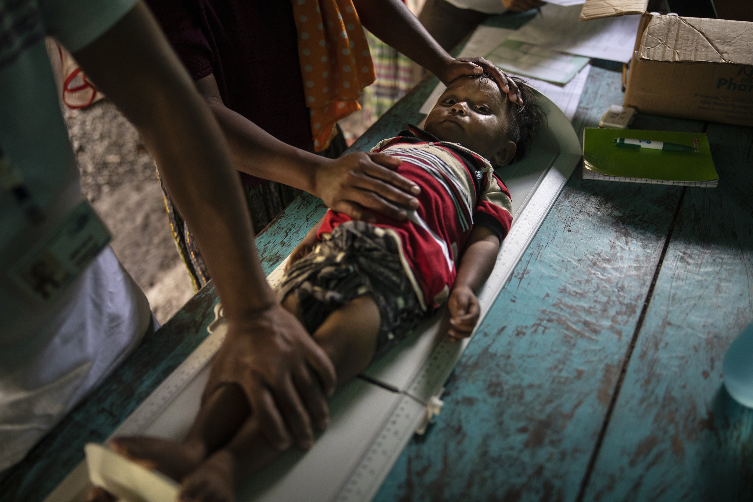  Sergio David Jom, 2, lies on a scale as he is measured during a wellness checkup in the makeshift settlement Nuevo Queja, Guatemala, on July 9, 2021. (AP Photo/Rodrigo Abd) 