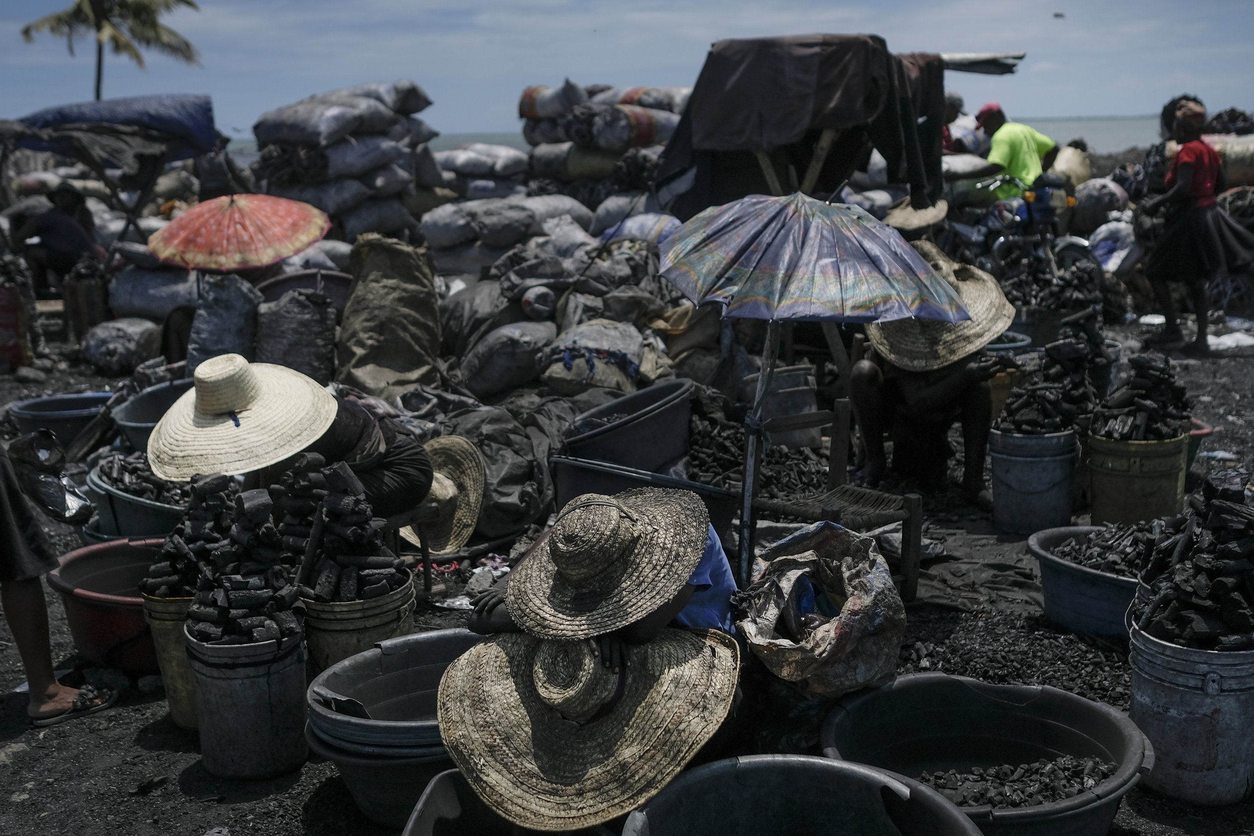  Vendors wear hats for shade as they sell cooking coal at a market in Cap-Haitien, Haiti, on July 22, 2021. (AP Photo/Matias Delacroix) 