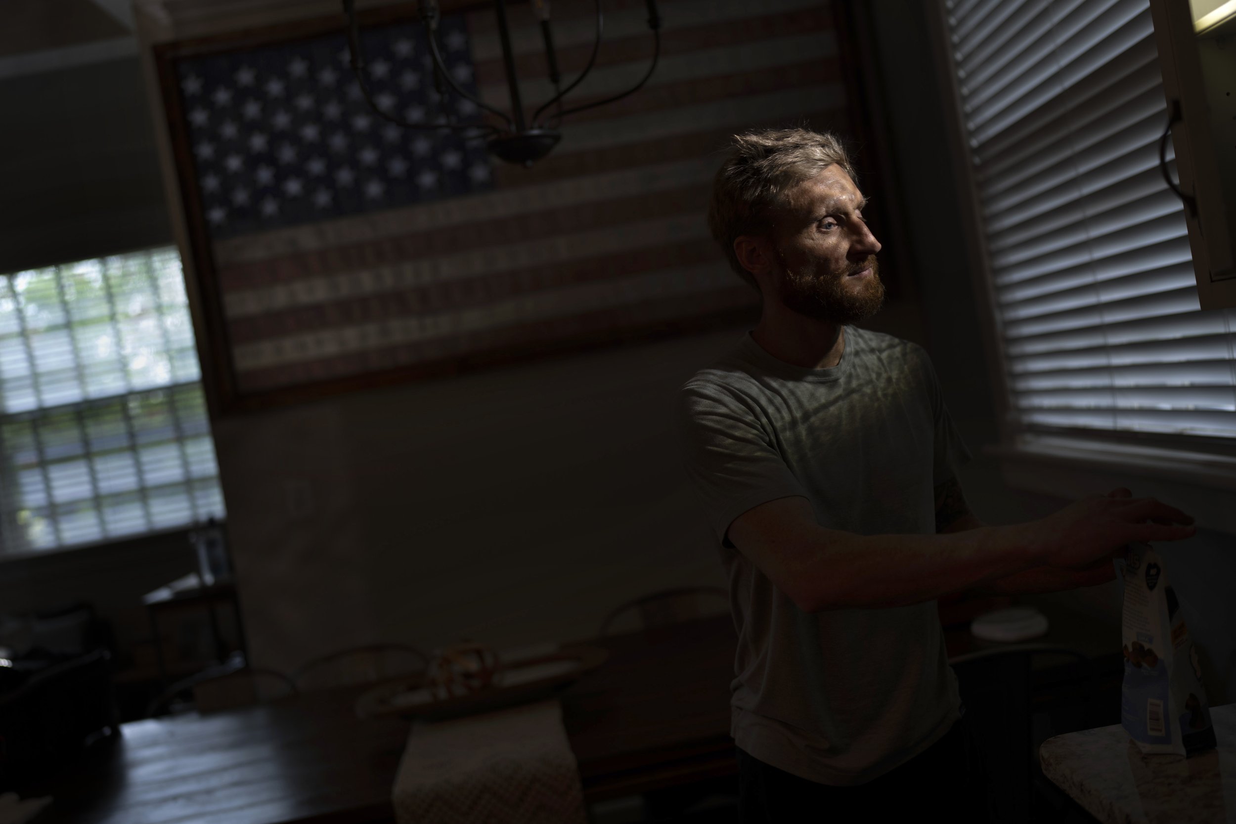  Brad Snyder, a Navy explosives expert who was blinded in a mine explosion in Afghanistan in 2011, prepares tea for his wife in their Princeton, N.J., home on Aug. 4, 2021. Snyder won the gold medal in the Triathlon PTV1 at the Paralympics in Tokyo o