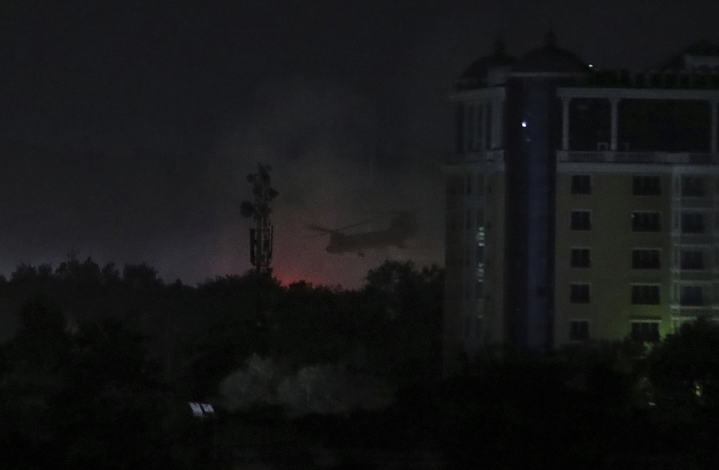  A U.S. Chinook helicopter flies near the U.S. Embassy as smoke rises in Kabul, Afghanistan, late Sunday, Aug. 15, 2021. (AP Photo/Rahmat Gul) 