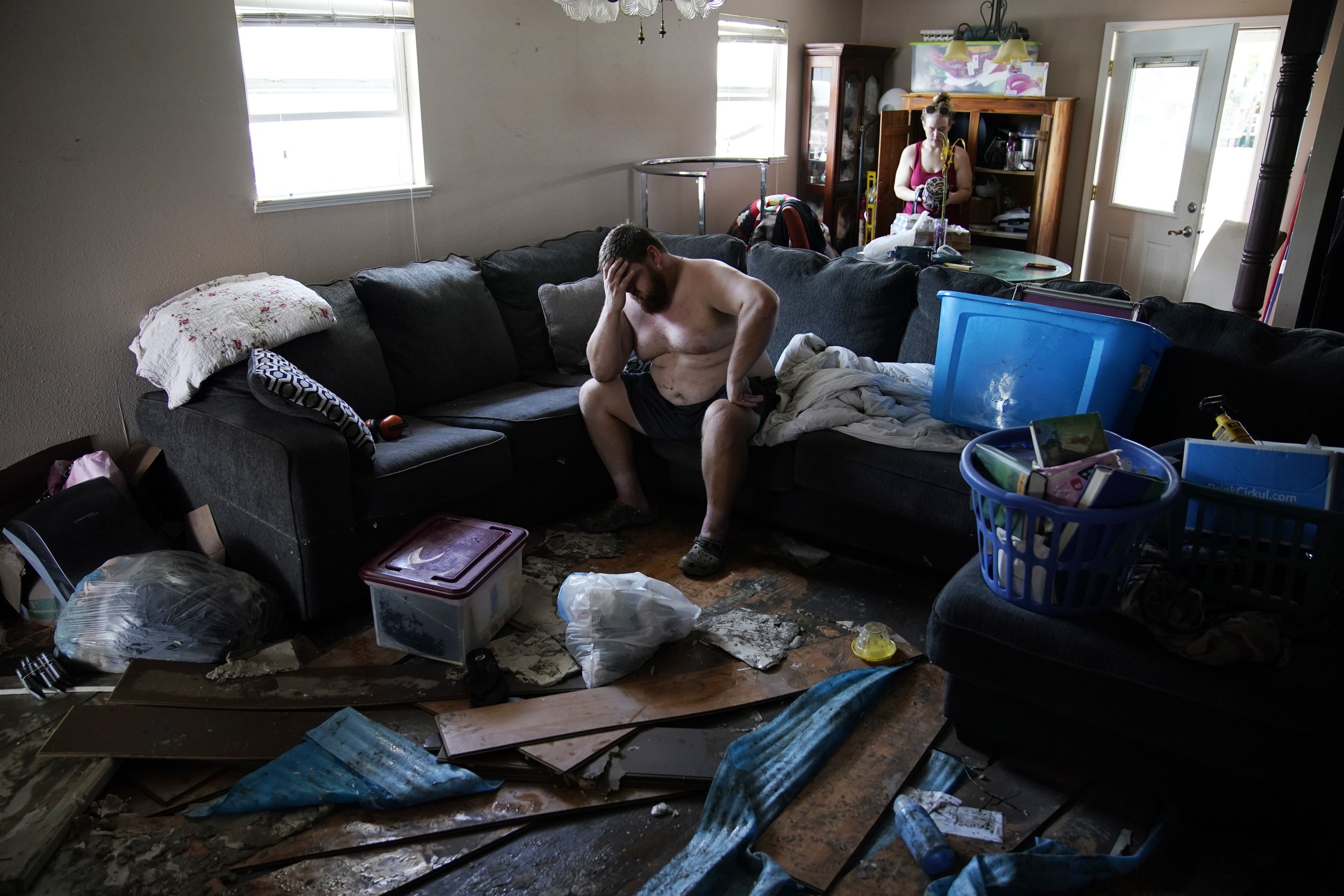  Josh Montford rests his head in his hand while going through his flood damaged home in the aftermath of Hurricane Ida, on Sept. 1, 2021, in Jean Lafitte, La. "I'm overwhelmed," said Montford as he searched for items to salvage. (AP Photo/John Locher
