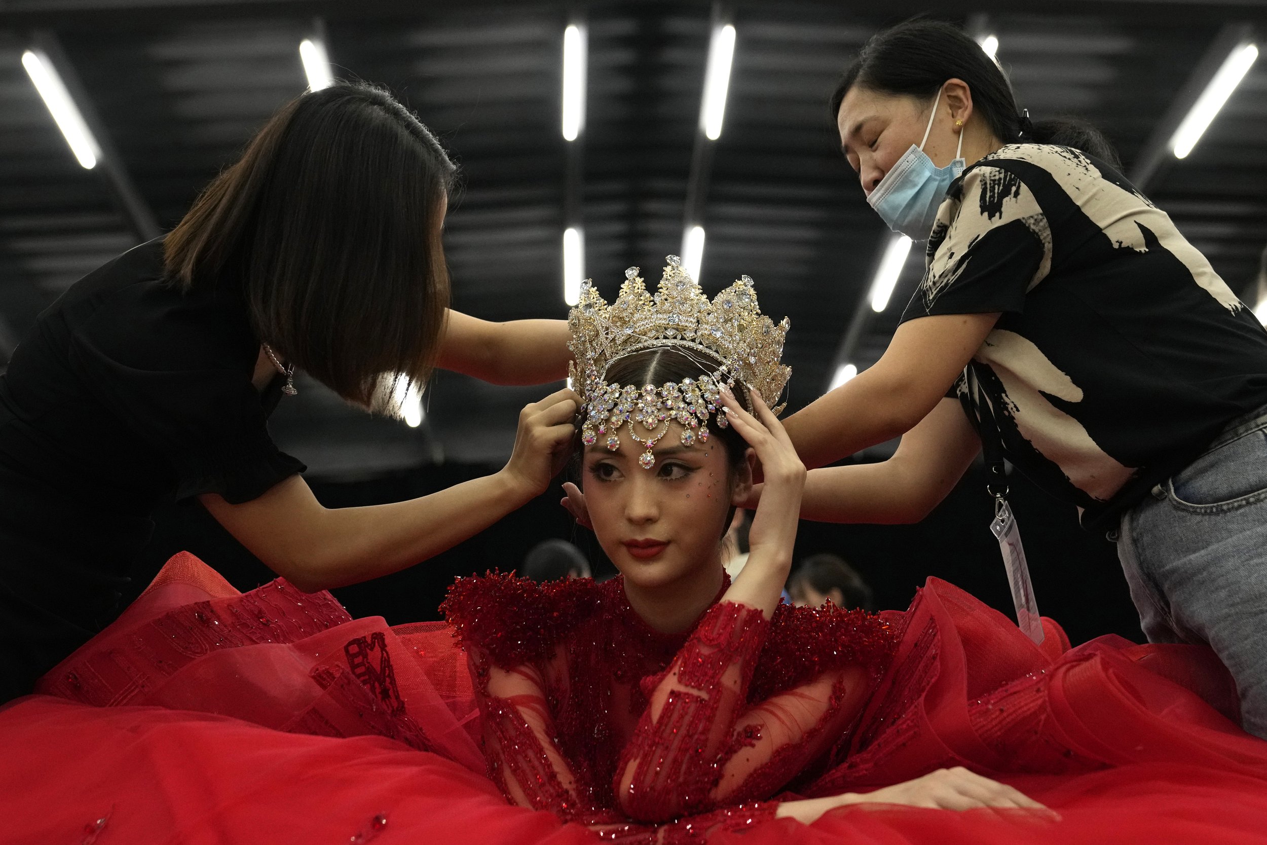  A model waits to have her headdress removed after a presentation of the William Zhang collection by designer Hongwei Zhang during the China Fashion Week in Beijing, on Sept. 8, 2021. (AP Photo/Ng Han Guan) 