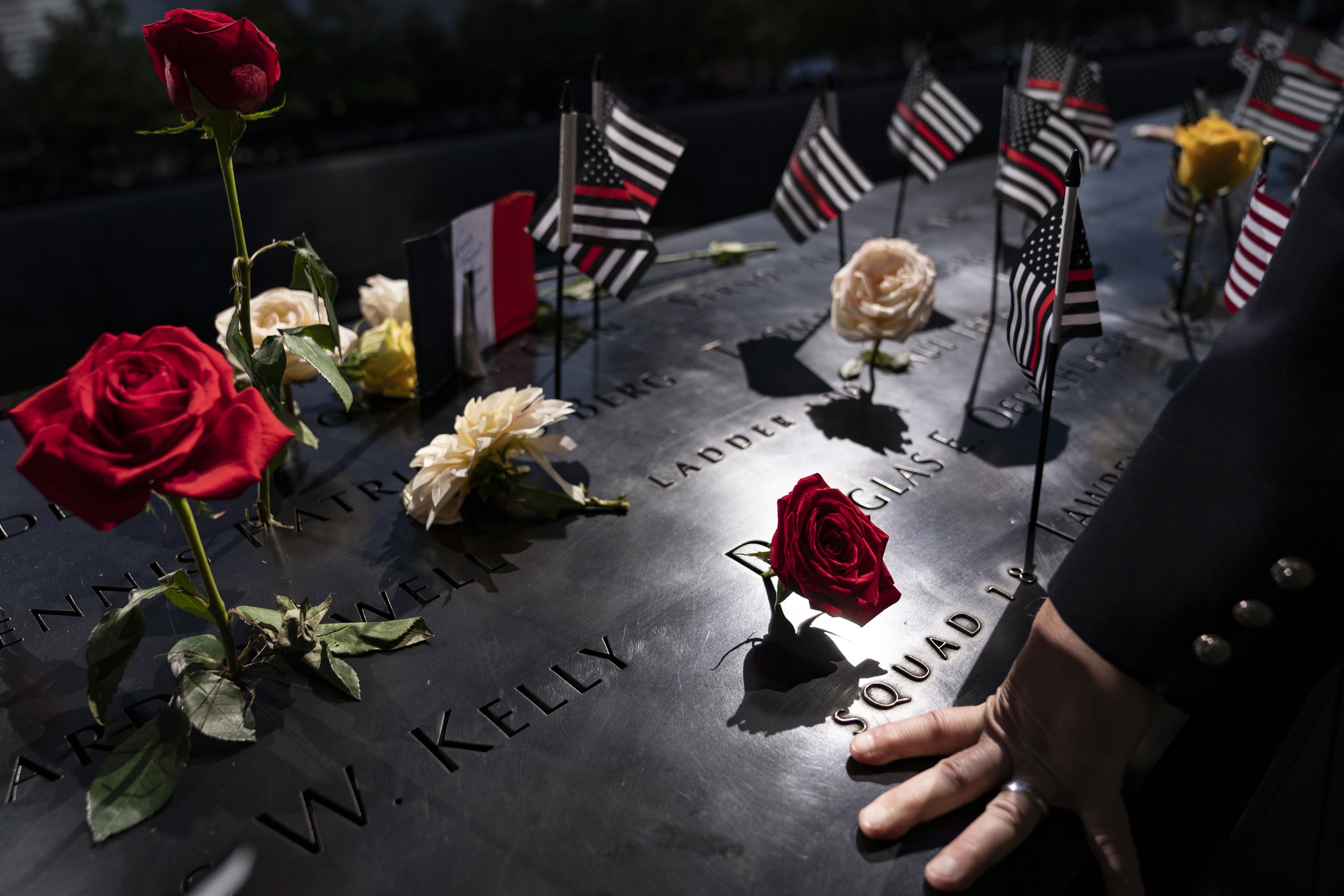  A firefighter places his hand on engraved names on the south memorial pool during a ceremony to commemorate the 20th anniversary of the Sept. 11 terrorist attacks on Sept. 11, 2021, at the National September 11 Memorial & Museum in New York. (AP Pho