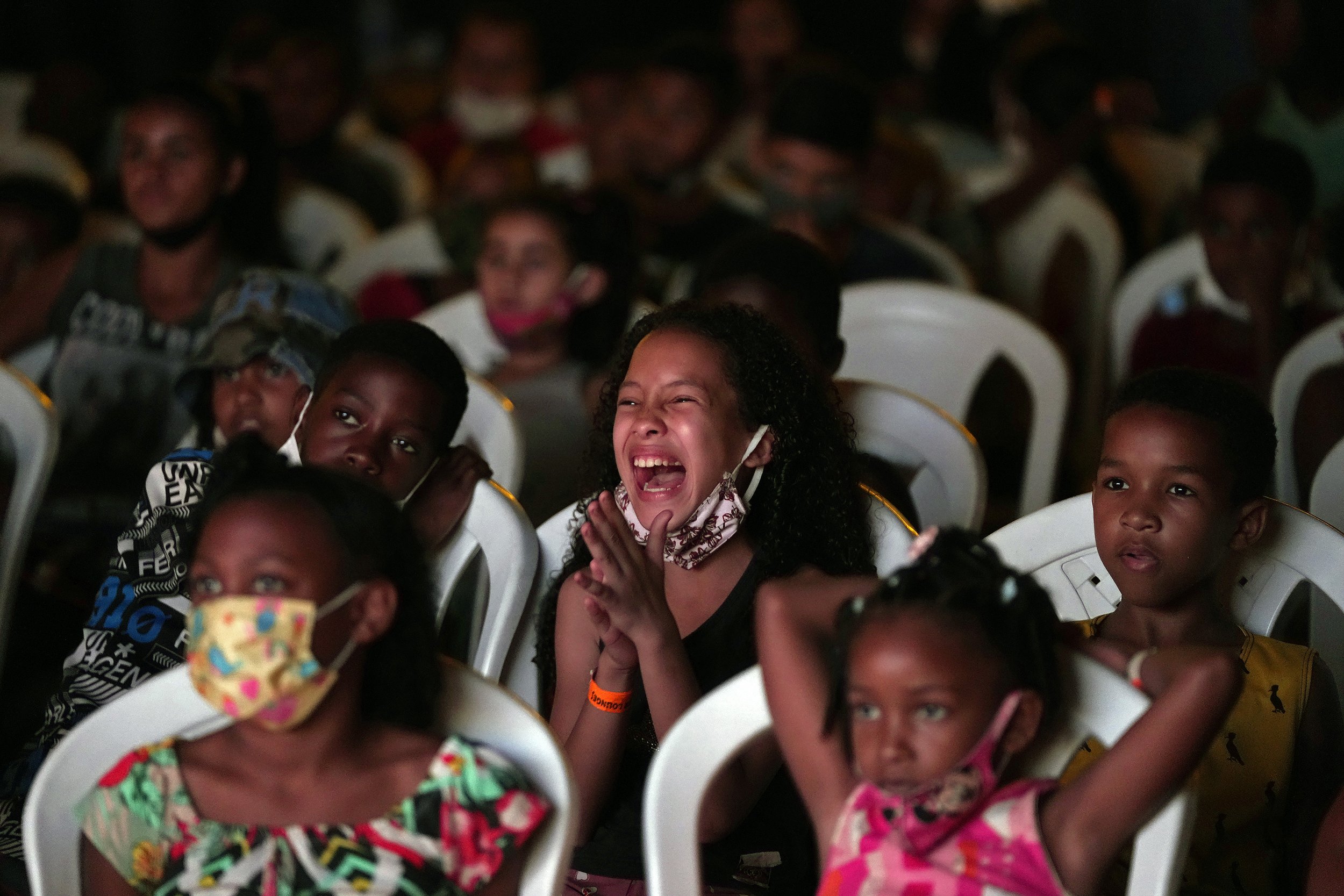  Children watch a movie of the "Cinema no Morro" or "Cinema on the hill" project in a cultural center at Vila Cruzeiro favela in Rio de Janeiro, Brazil, on Sept. 13, 2021. (AP Photo/Silvia Izquierdo) 
