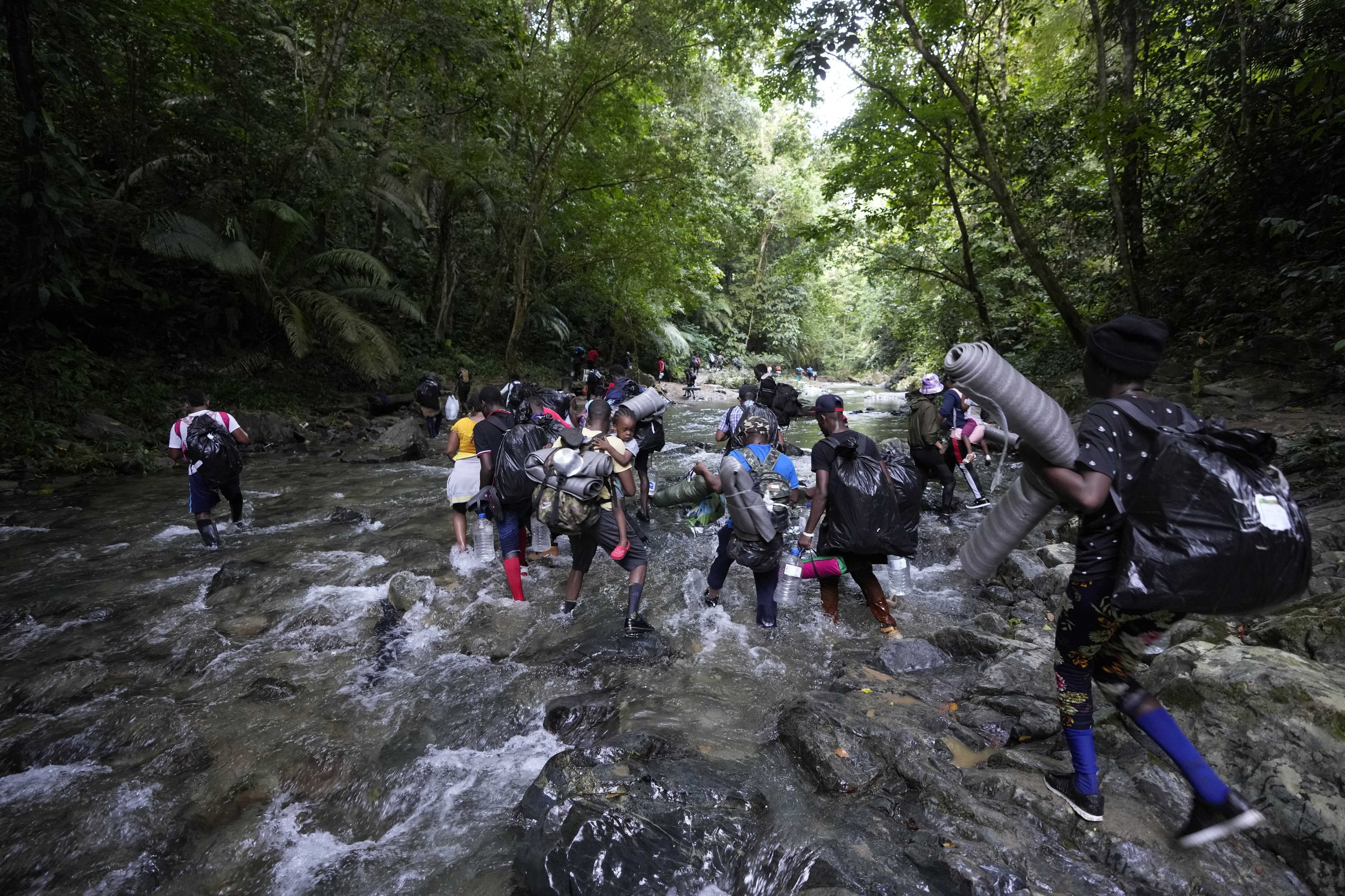  Migrants cross the Acandi River on their journey north, near Acandi, Colombia, on Sept. 15, 2021. The migrants, mostly Haitians, are on their way to crossing the Darien Gap from Colombia into Panama dreaming of reaching the U.S. (AP Photo/Fernando V